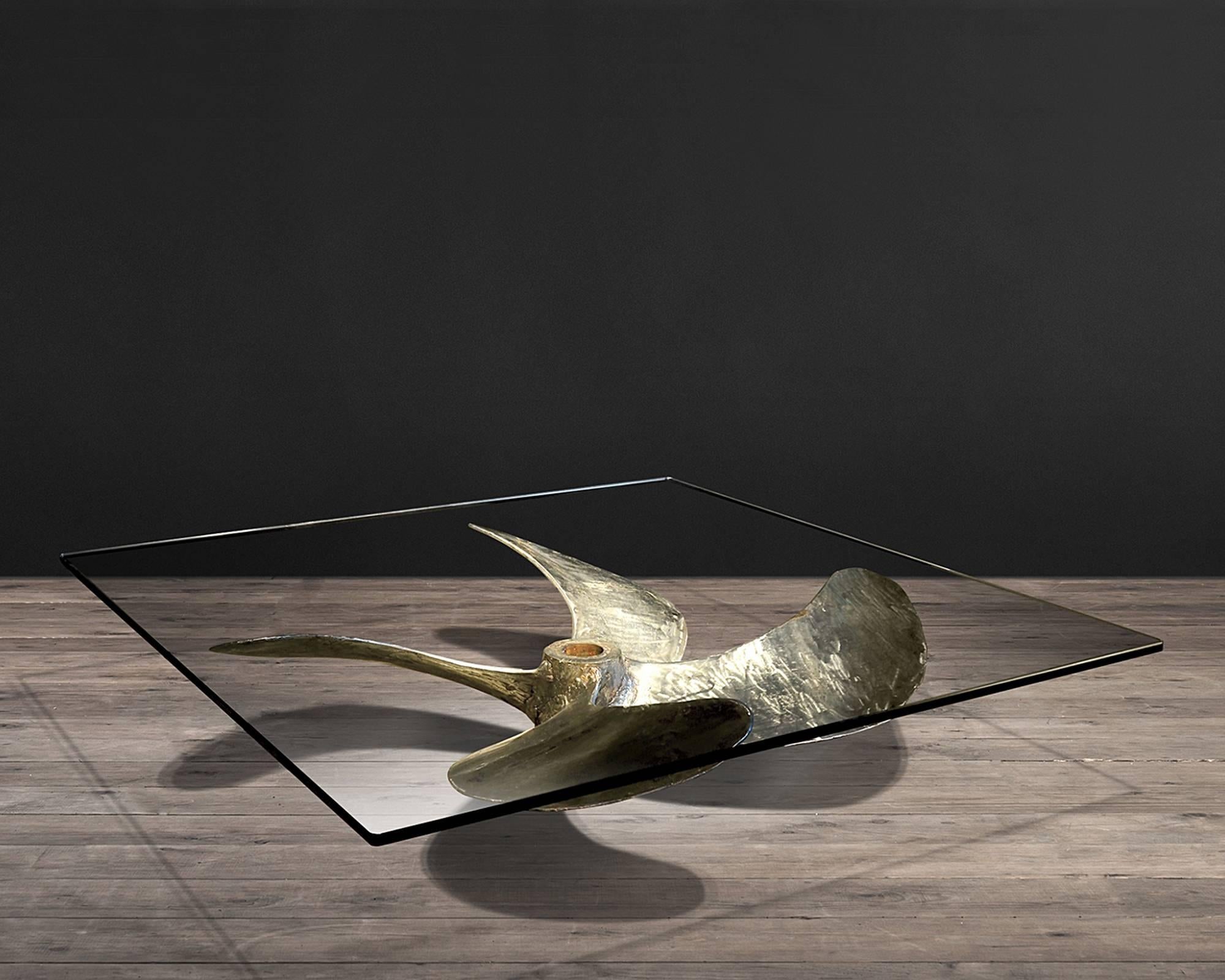 Coffee table Propeller is handcrafted from the
propellers of Chinese fishing junks, simple pane
glass top.
