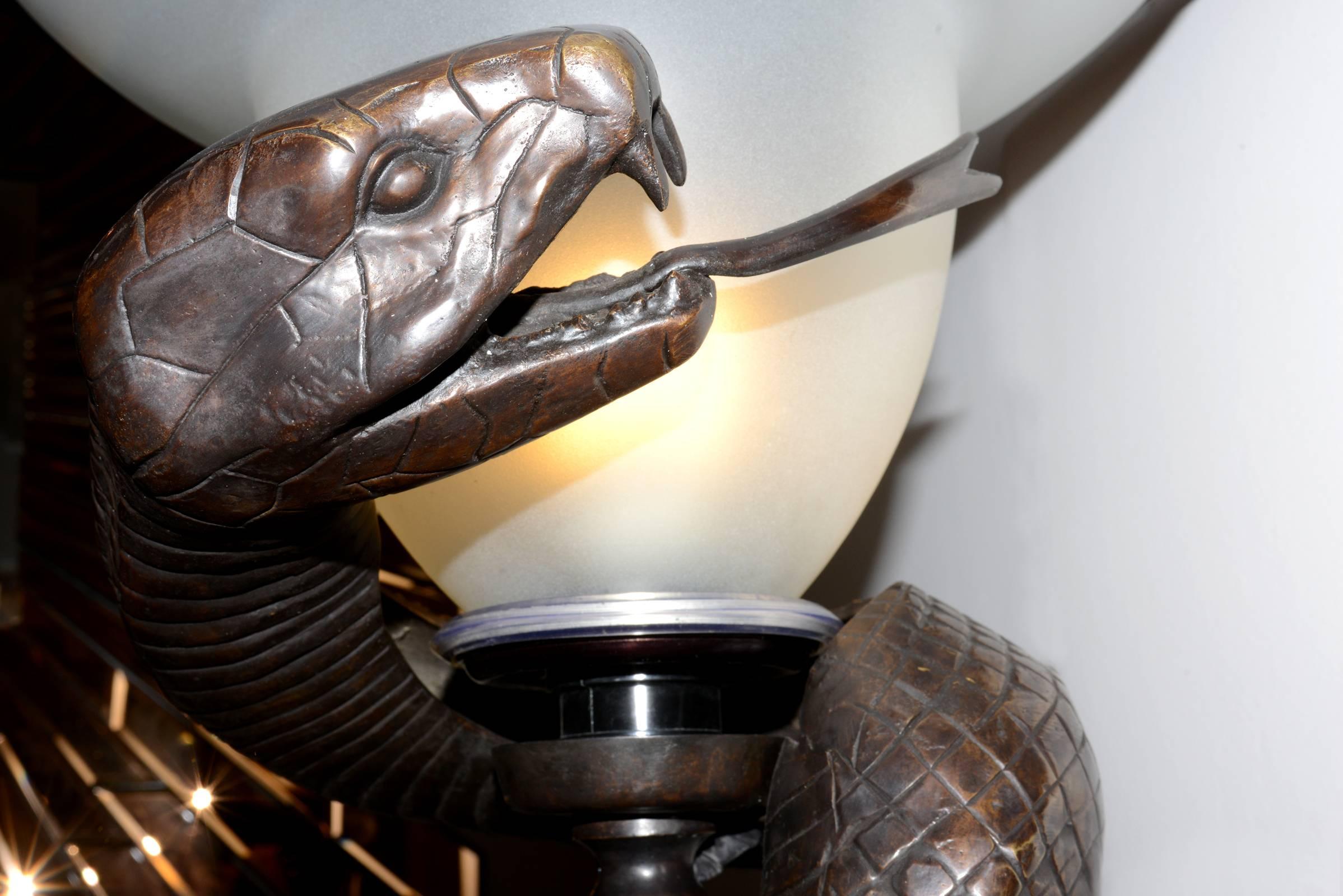 Floor lamp snake in bronze highlight 
finish with frosted glass lamp. 
One lamp holder type E27, max 40 watt. 
220-240 volt.

 