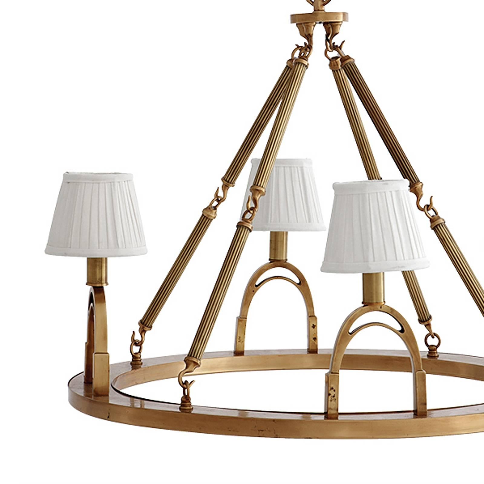 Chandelier Stirrup with structure in aged brass 
finish. Four bulbs lamp holder type E14, max 40 watts. 
Including four pleated shades in black or in white color. 
Ø70xH61cm, price: 2990,00€.
Also available with nickel finish structure including