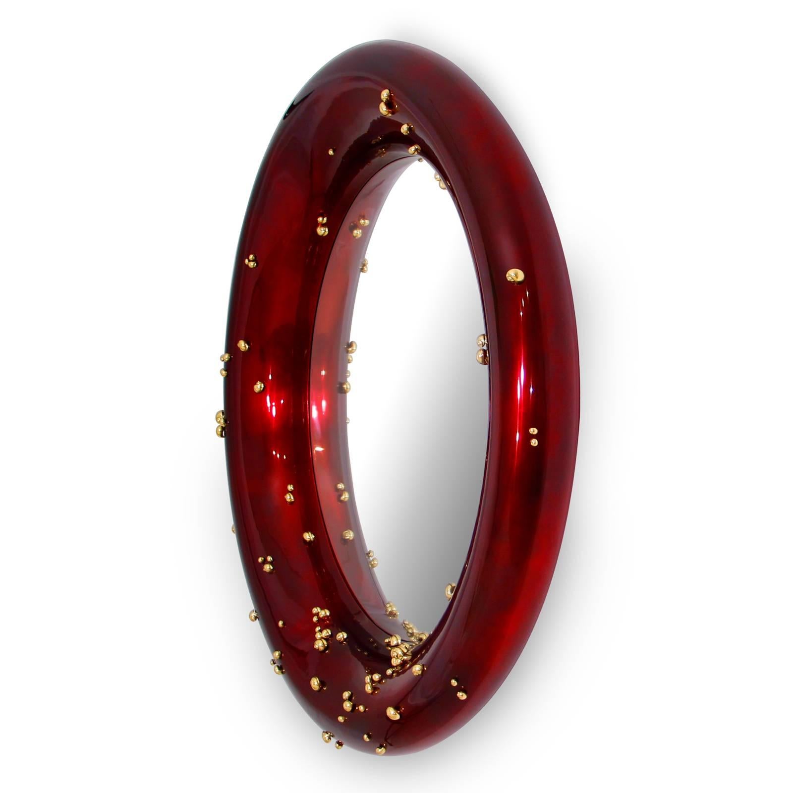Miroir rouge avec cadre en bois sculpté avec
rouge-foncé brillant verni avec rond transparent 
verre miroir. Décoré de petits escargots en
laiton massif poli tout autour du cadre.
