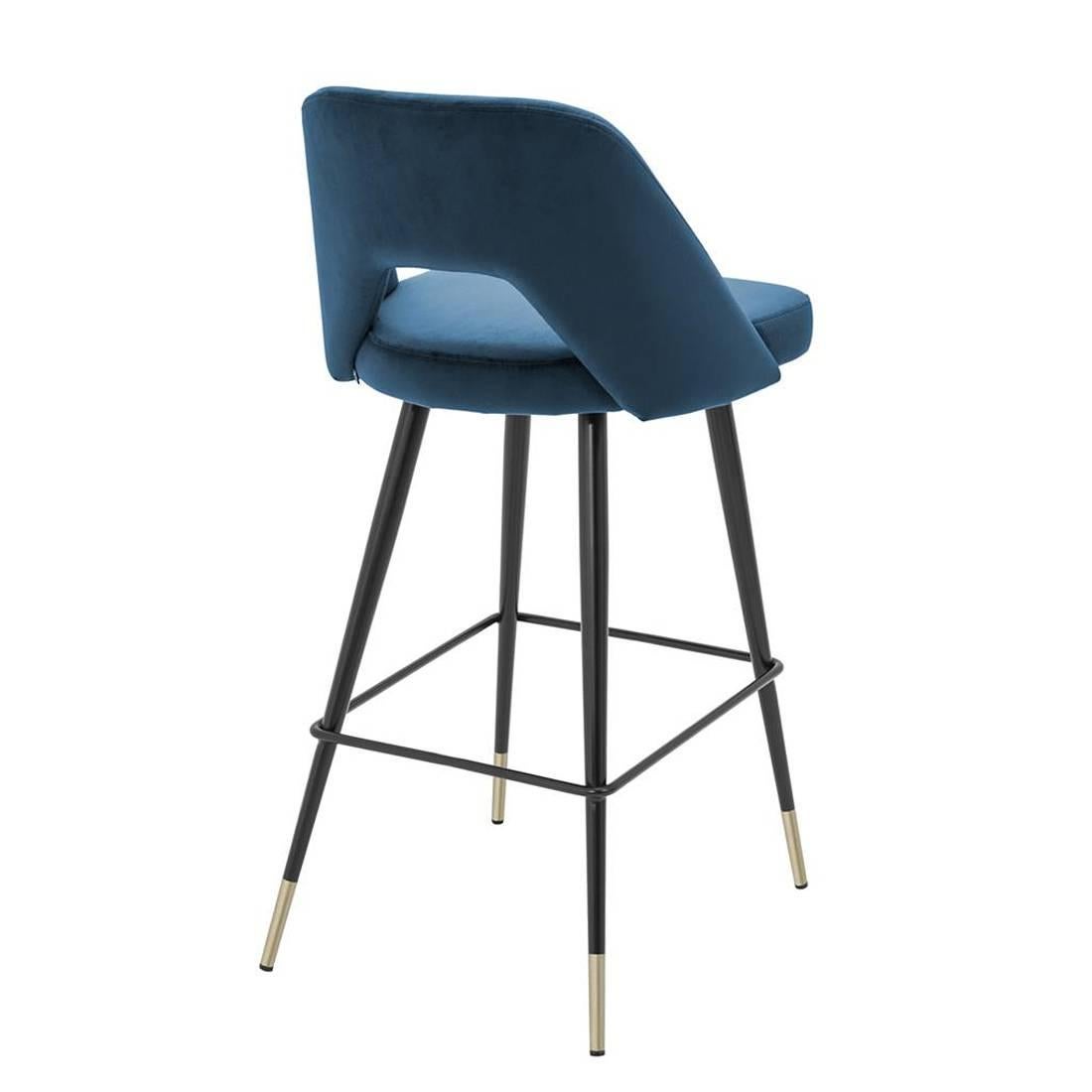 Bar Stool Perfecto Large upholstered with blue velvet 
fabric with fire retardant treatment. Base structure in iron
in black finish with polished brass feet.
Also available upholstered with red or green velvet 
fabric. Also available in Bar Stool