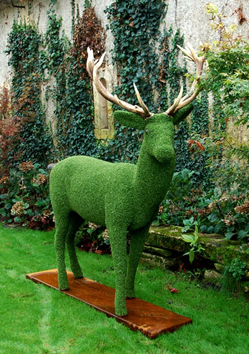Dear shape in synthetic turf, with antler, on metal base.
