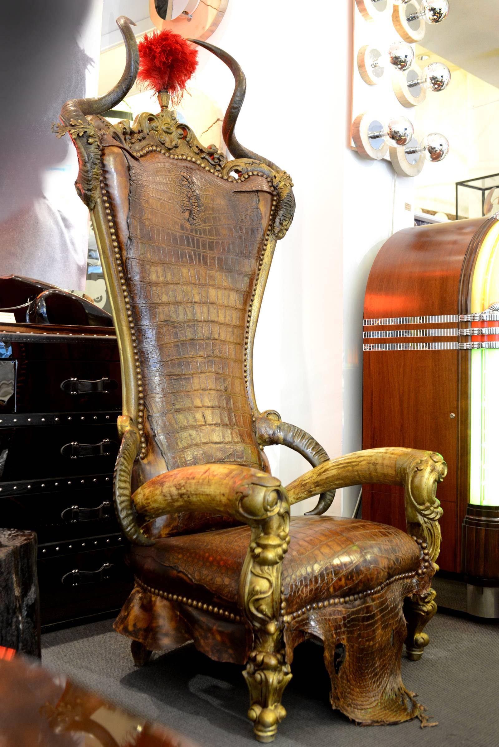 Armchair with genuine alligator and genuine goat. 
Top with kudu horns and red ostrich feathers. Arms with
water buffalo (Asia) and zebu horns. Bronze finish. 
Handmade in France, 2016.
