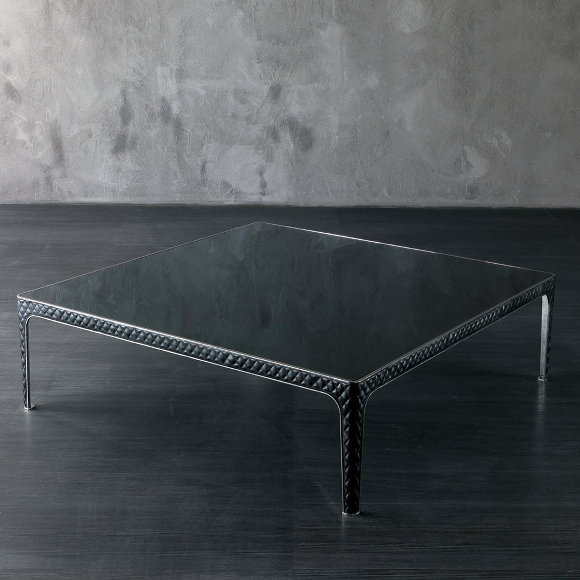 Coffee table with structure in polished stainless steel
with black glass top. Legs covered with capitonated black 
genuine leather (Cat C).
Available in:
L90,9xD90,9xH38,8cm, price: 6900,00€.
L130,9xD130,9xH38,8cm, price: 8500,00€.
Also available