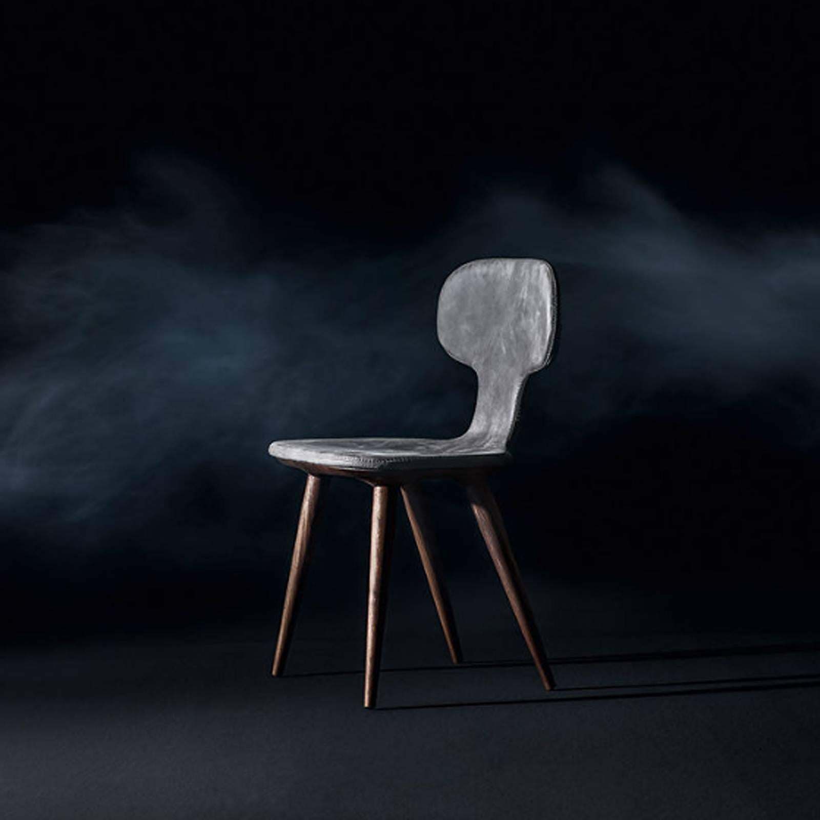 Dining Chair Racing with grey Swedish genuine leather 
made with sinuous and enveloping forms, visible stitching, 
with solid walnut wood shaped structure. Natural wax of 
vegetable origin with pine extracts finish. 
Also available with brown or