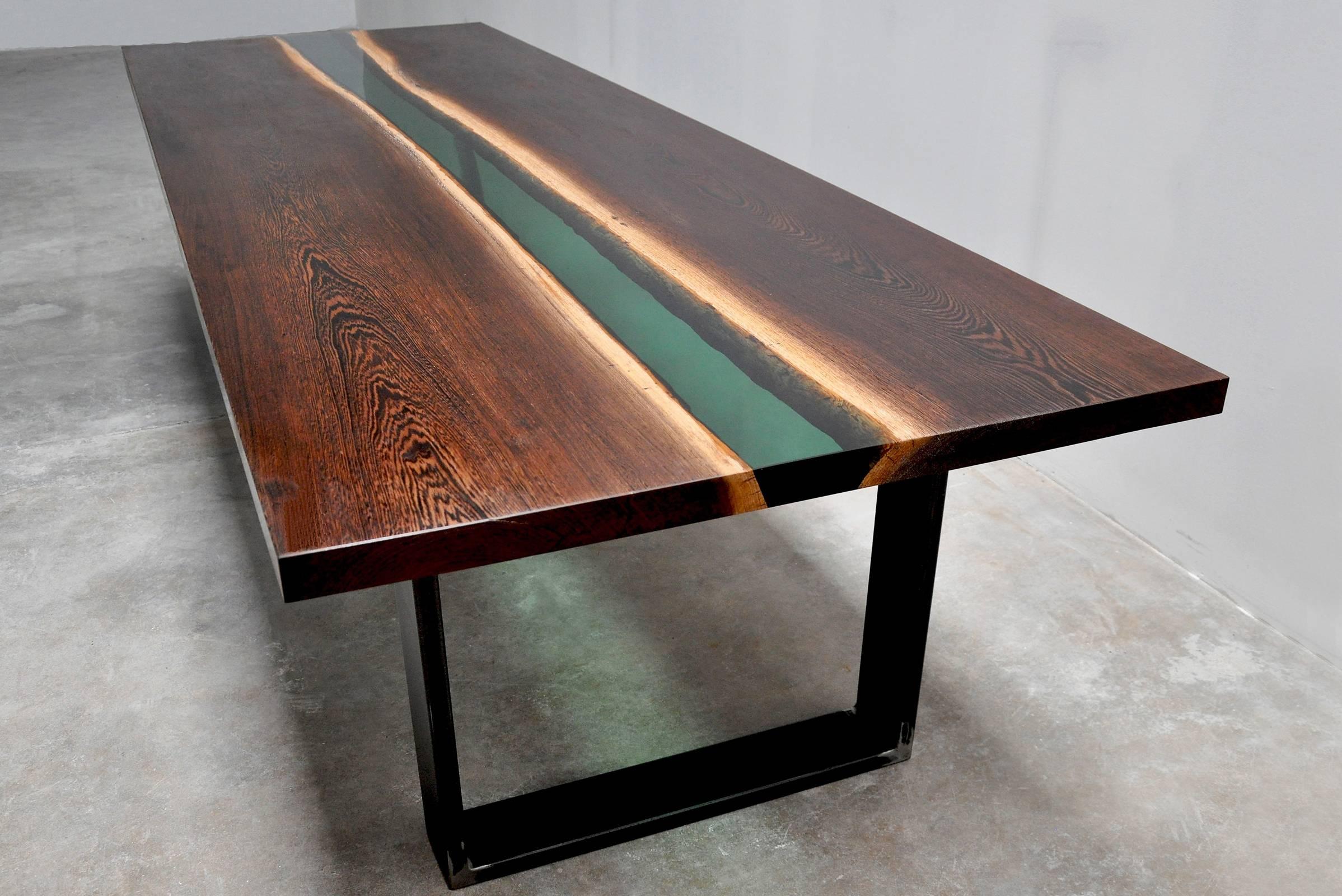 Dinning table or conference table in Wenge wood from 
equatorial and tropical africa. Two Wenge wood slats joined 
by a green transparent resin emerald color liked. A very 
strong wood very difficult to work with which give marvellous 
knots of