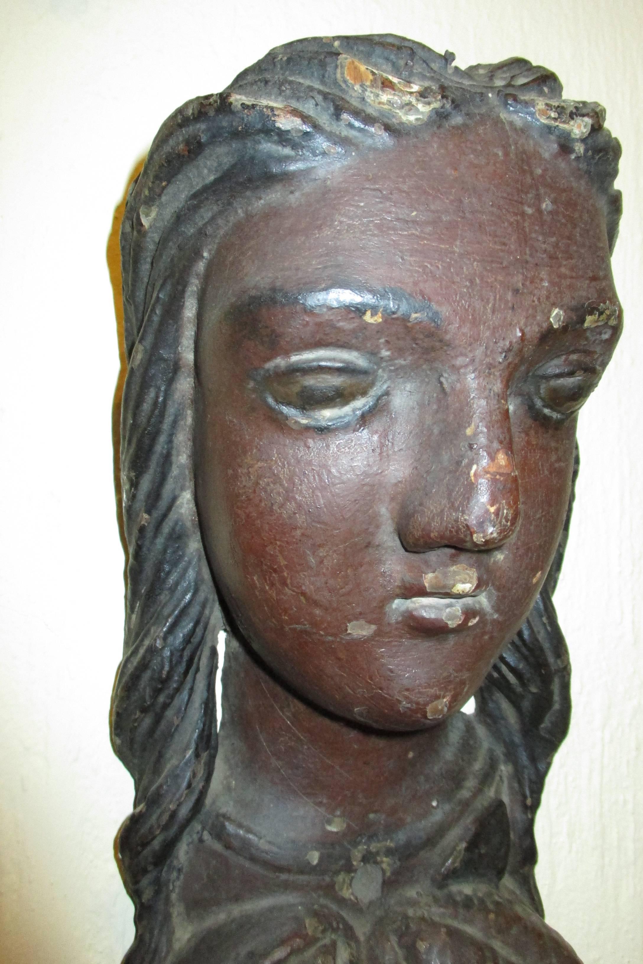 Of unknown origin this carving is reminiscent of the female figureheads found on early ships.  The wood appears to be pine or some other soft wood.   It is  like a Europeans perception of dark skinned peoples from the cocoa growing regions.  An