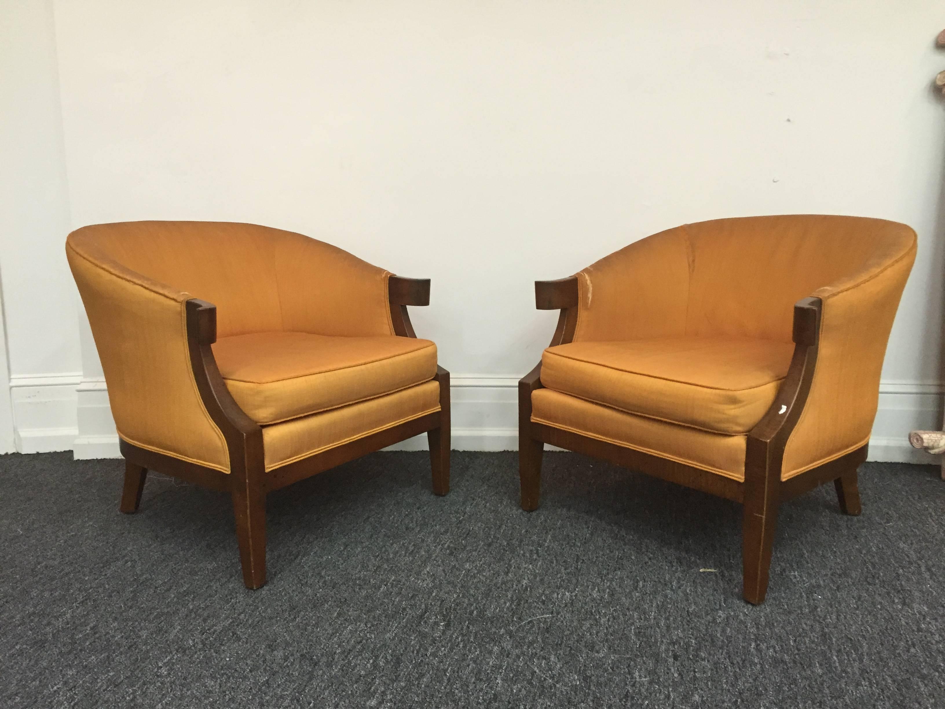A pair of elegant Art Deco slipper chairs in the manner of Tommi Parzinger with sculpted flared arms.