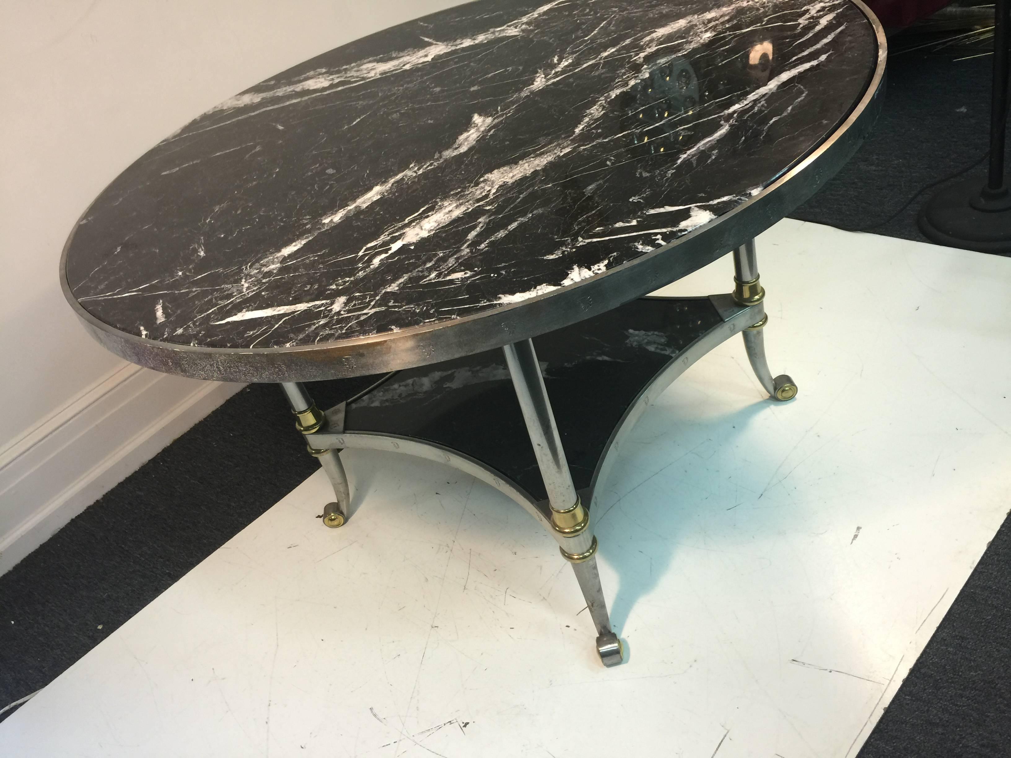 An exceptional French round marble dining table by Maison Jansen with steel frame and brass accents, circa 1940.