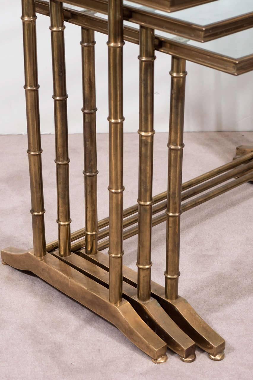 A fabulous set of three French faux bamboo brass and glass nesting or stacking tables, circa 1960.

Large: 26