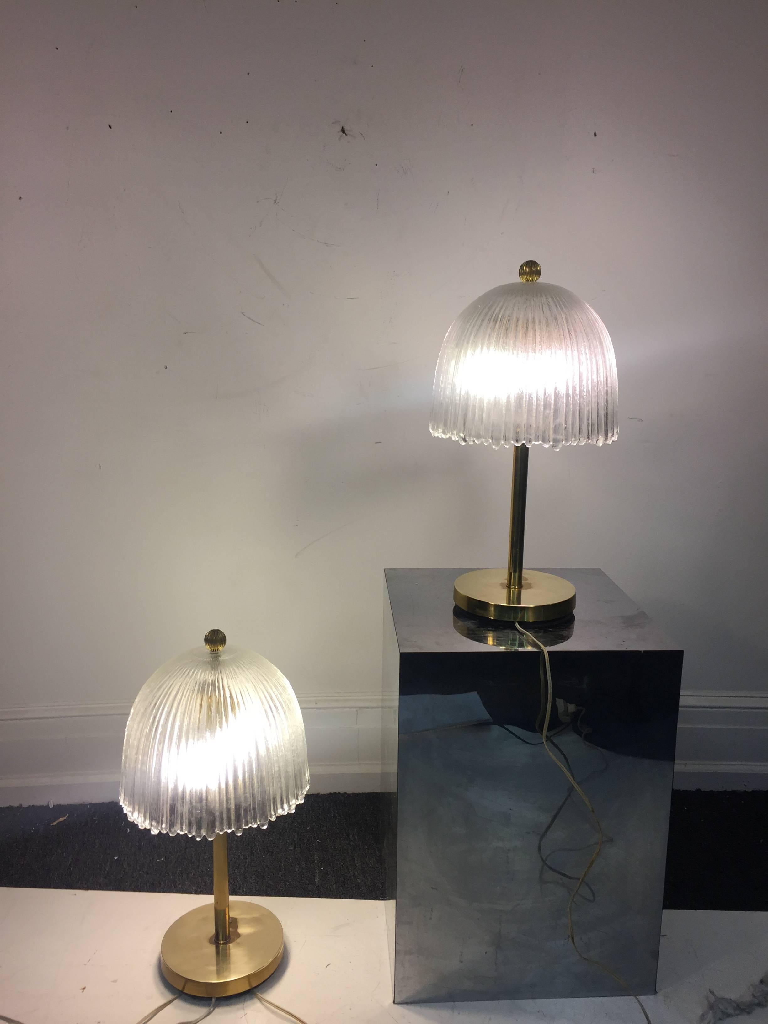 An elegant pair of French table lamps with glass tulip-shaped shades and brass bases in the manner of René Lalique, circa 1960. Good vintage condition with age appropriate wear.