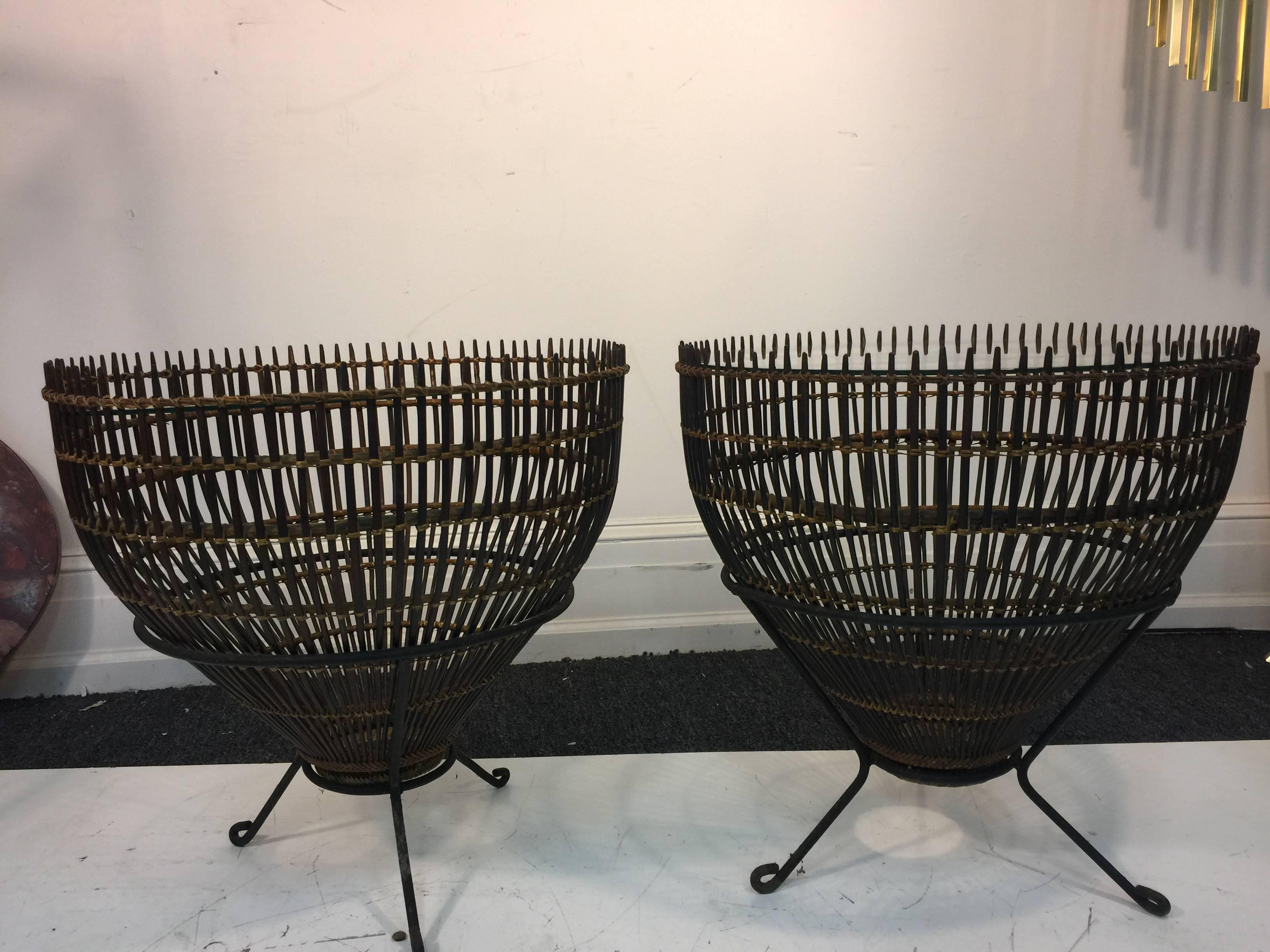 A fantastic pair of Franco Albini Italian side tables constructed from rattan fish baskets, and on sculpted iron bases, circa 1950. Good vintage condition with age appropriate wear.