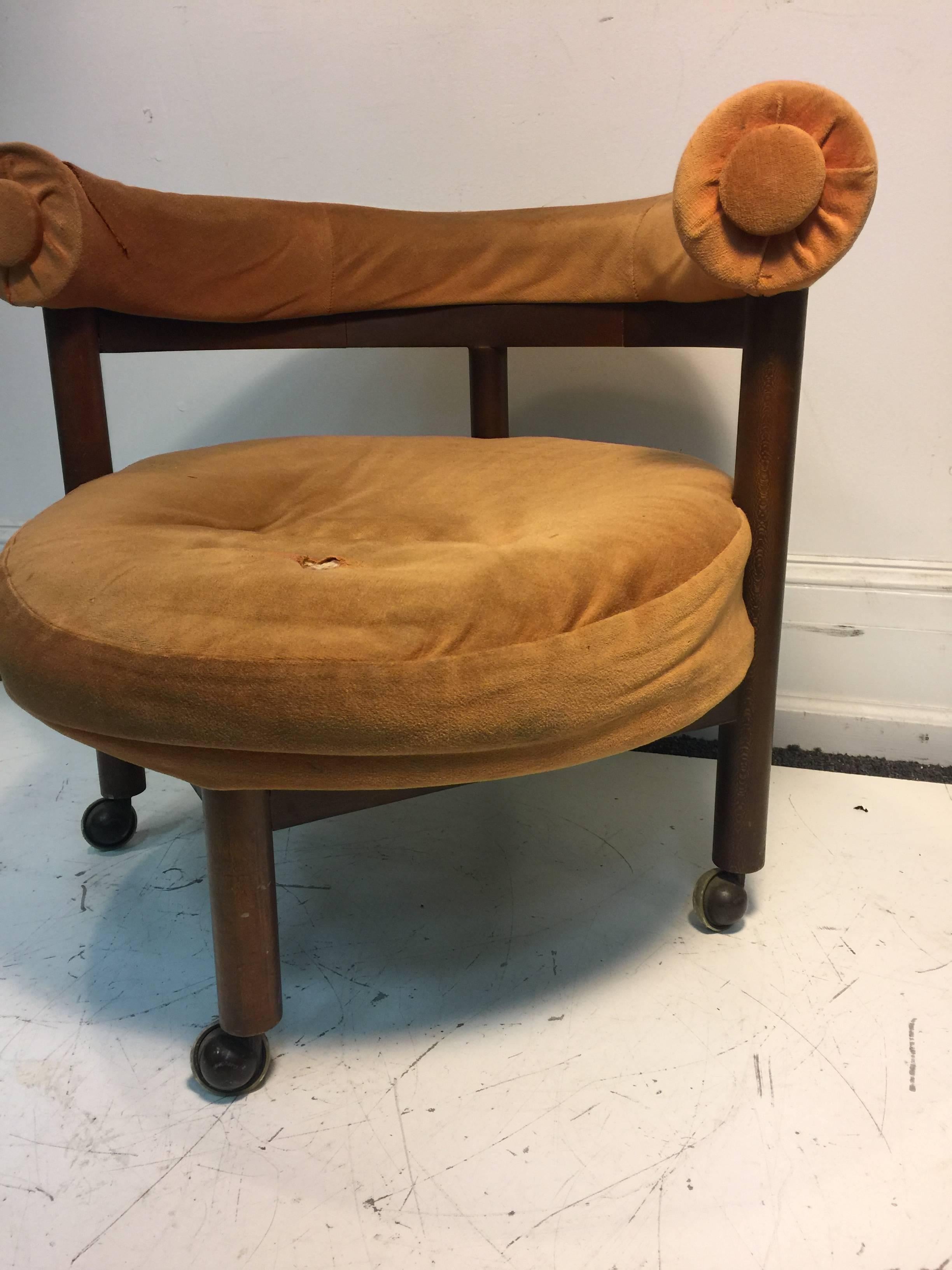 An unusual Danish Modern round chair on casters in the manner of Hans Wegner, circa 1970. Good vintage condition with age appropriate wear. Recommended re-upholstery.