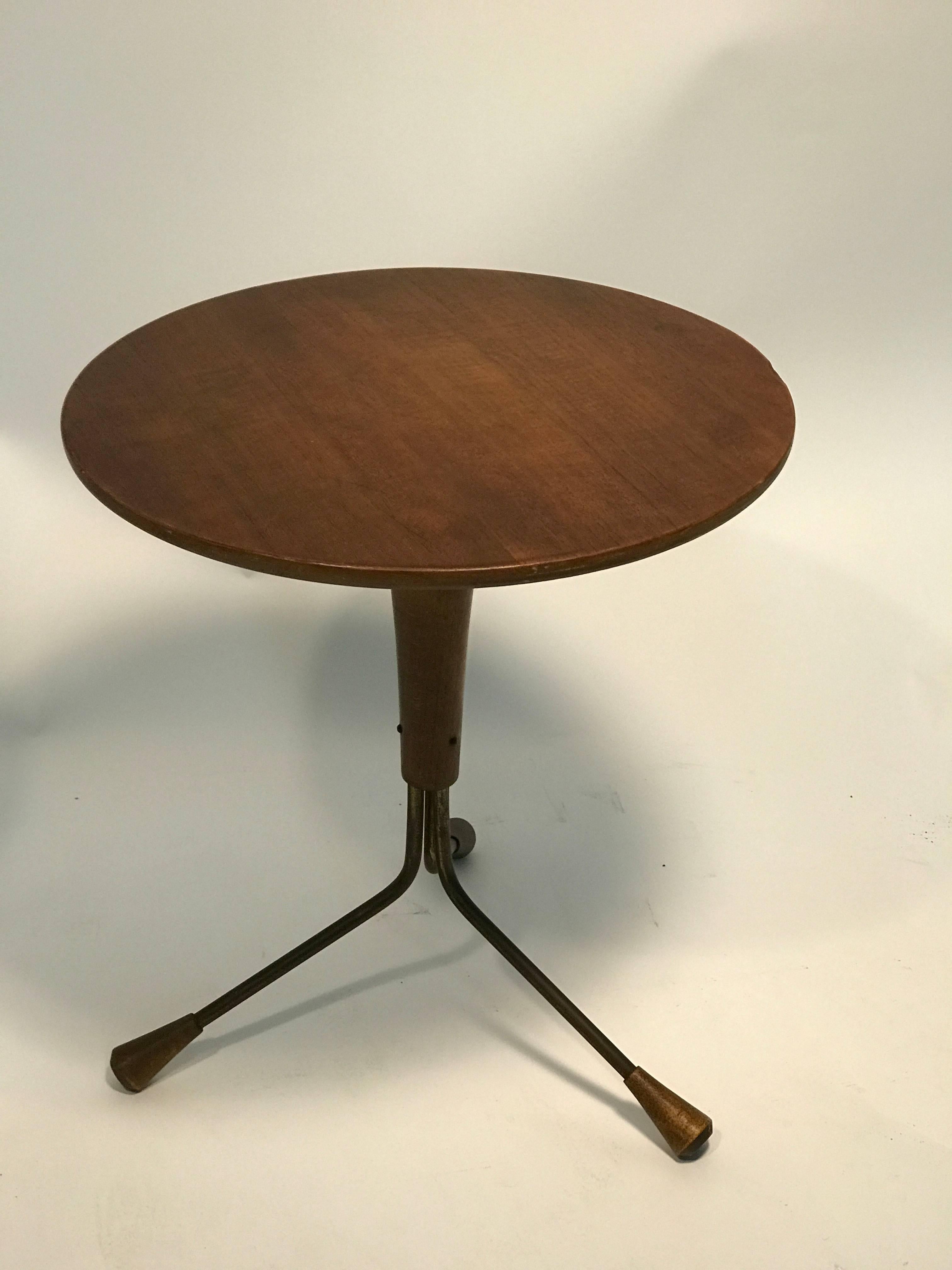 A great Danish modern pair of adjustable wood and iron side tables with tripod bases and fantastic flared legs in the style of Gio Ponti, circa 1970. One table is two inches higher than the other. Good vintage condition with age appropriate wear.