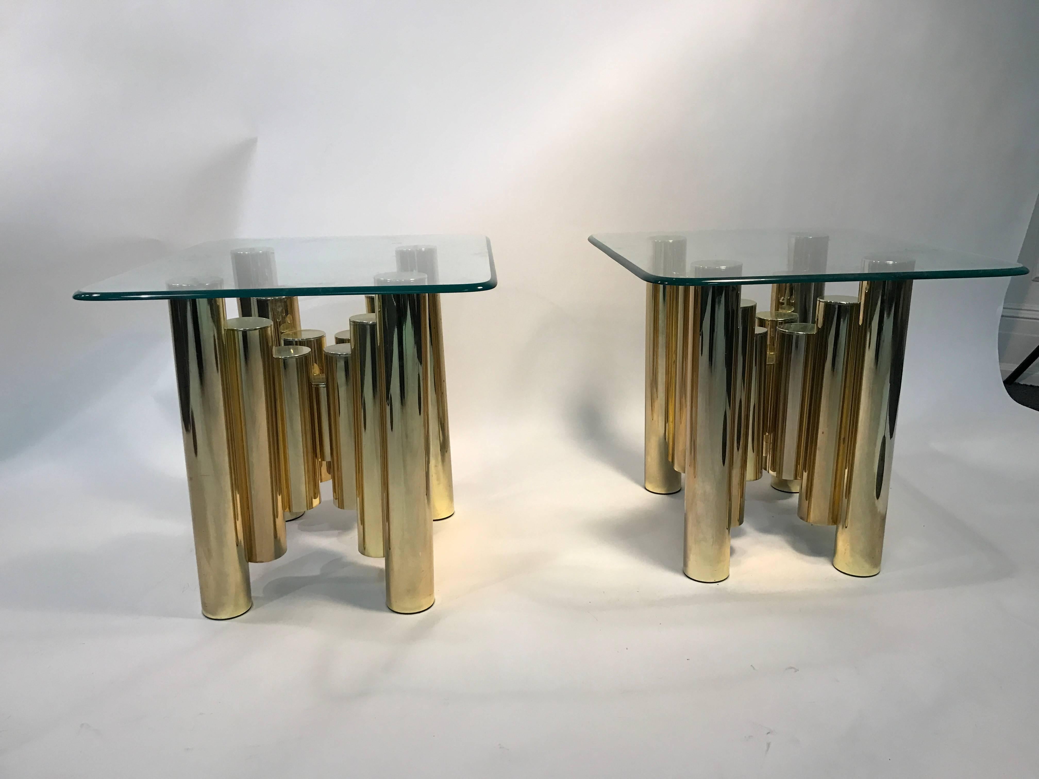 A terrific pair of brass tubular side, or end tables with glass tops in the manner of mastercraft, circa 1970. Good vintage condition with age appropriate wear.