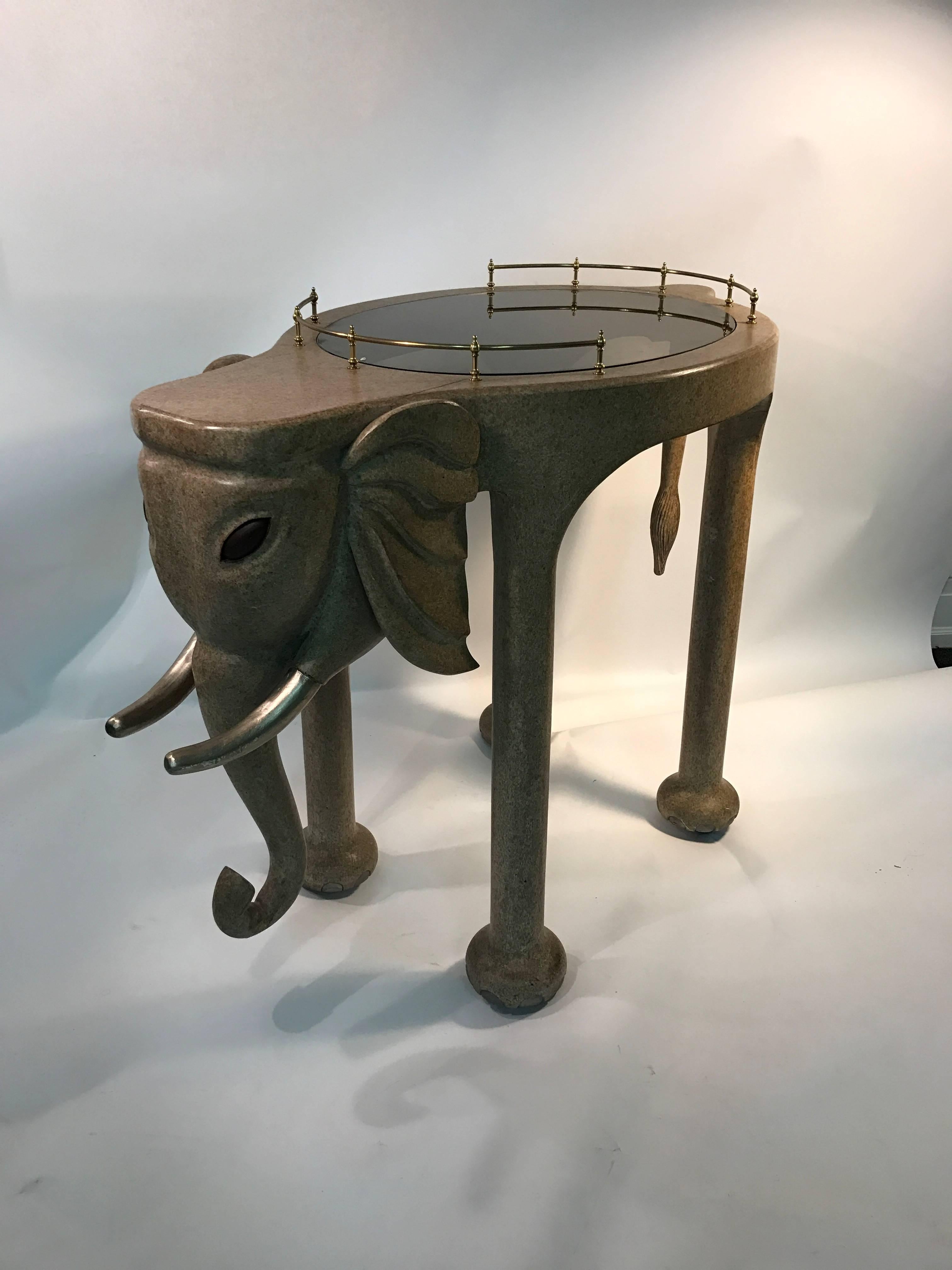 An exquisite and rare elephant bar cart by Marge Carson with brass-gallery, inset glass top, and wheels, circa 1980. Original label underneath. Great vintage condition.