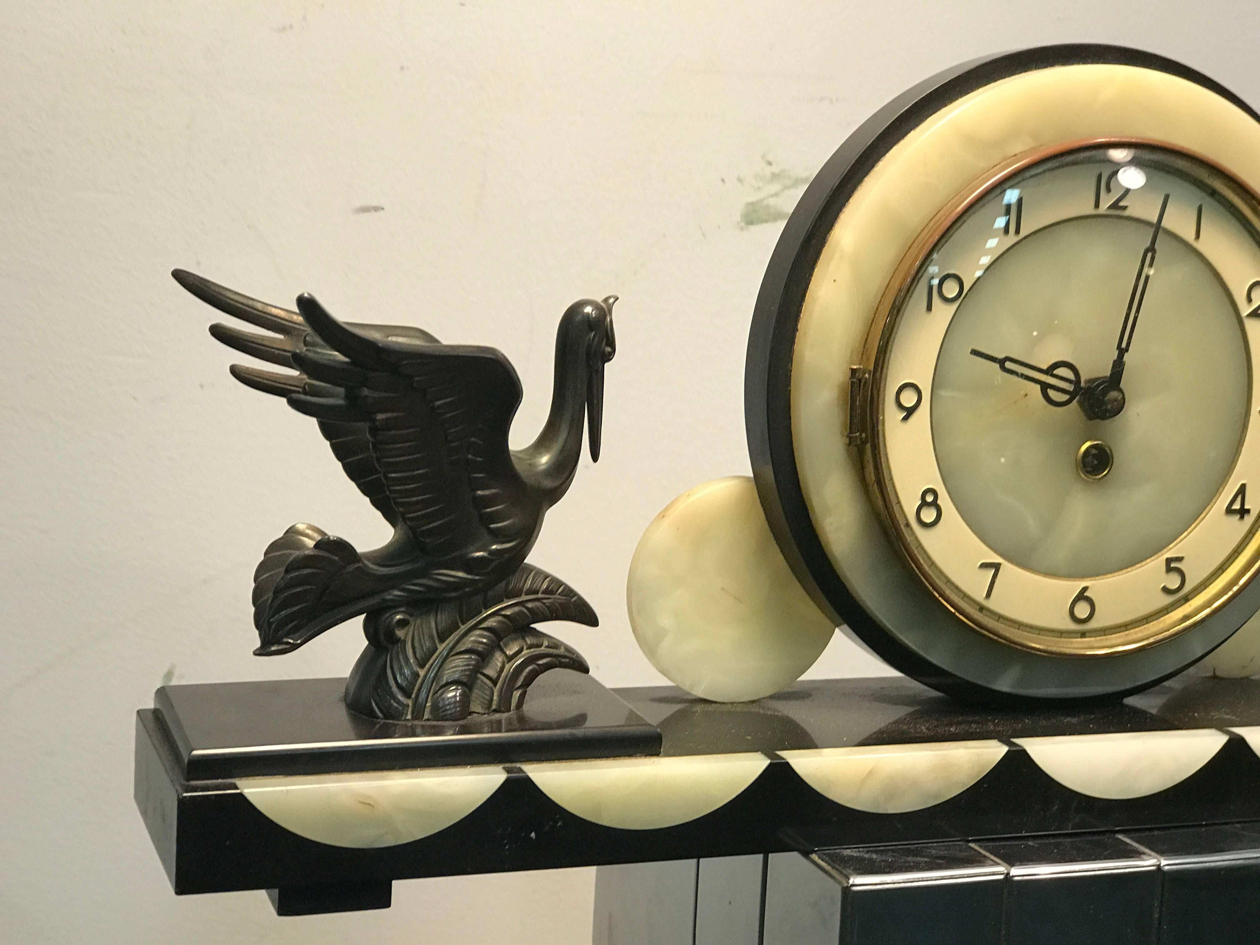 A beautiful French Art Deco marble and onyx mantel clock with white metal heron figurines, circa 1930. Good vintage condition with some wear appropriate with age.