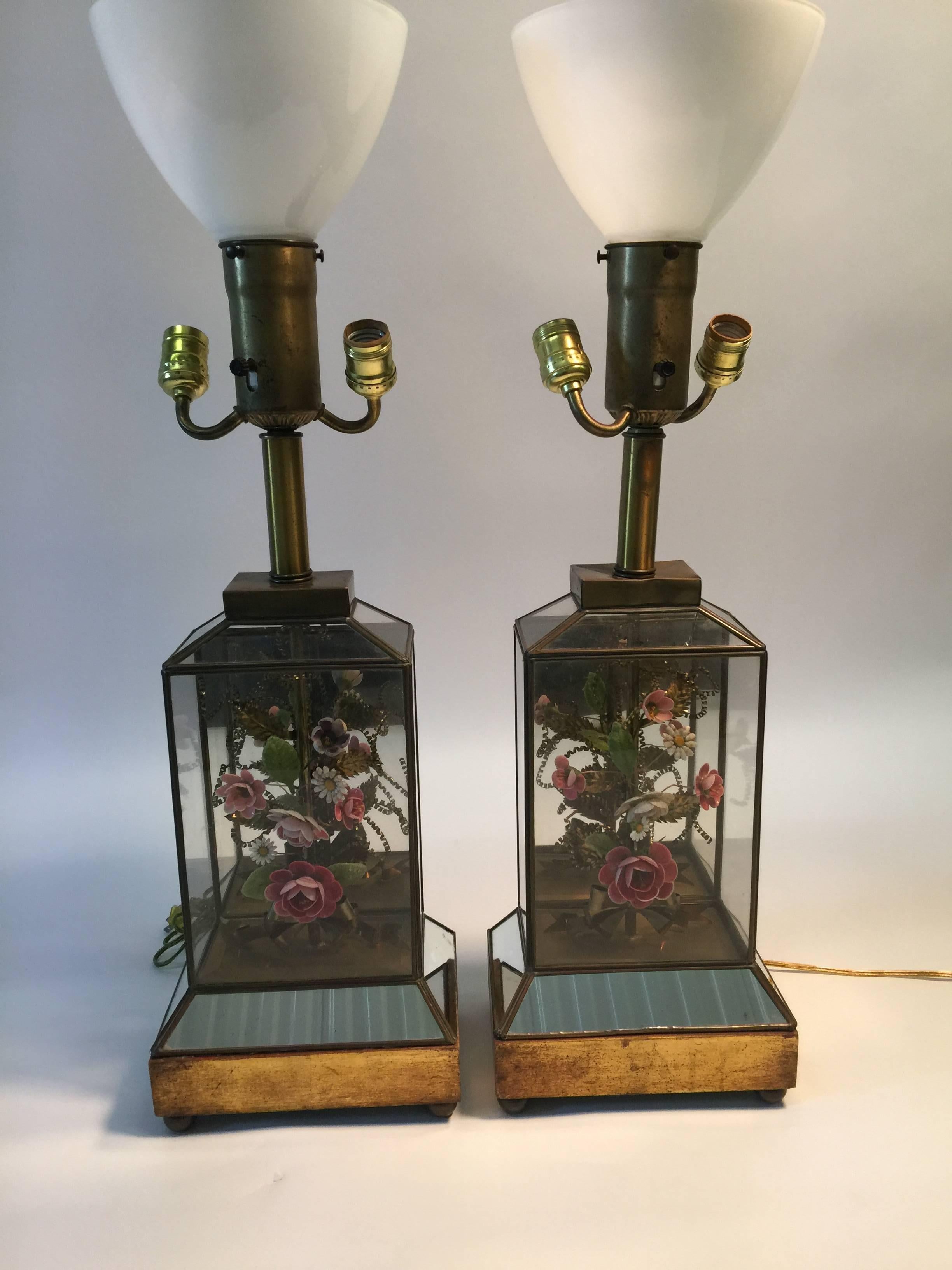  Spectacular Pair of shell and wax flowers with brass leaves and tendrils garnished with a brass sheet metal bow dioramas, encased in glass and brass framed showcases. Standing on a giltwood and mirrored bases these are beautifully made. One lamp