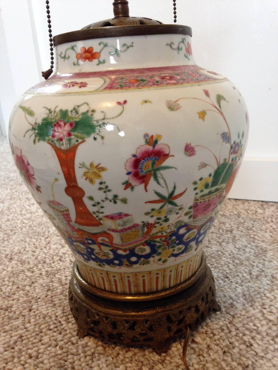 A beautiful Chinese porcelain ginger jar famille rose design lamp, circa 1900s.
Intricately patterned with Flowers and vase designs. In very good condition with no chips or cracks. Nicely mounted on an ornate bronze base fitted with a double socket