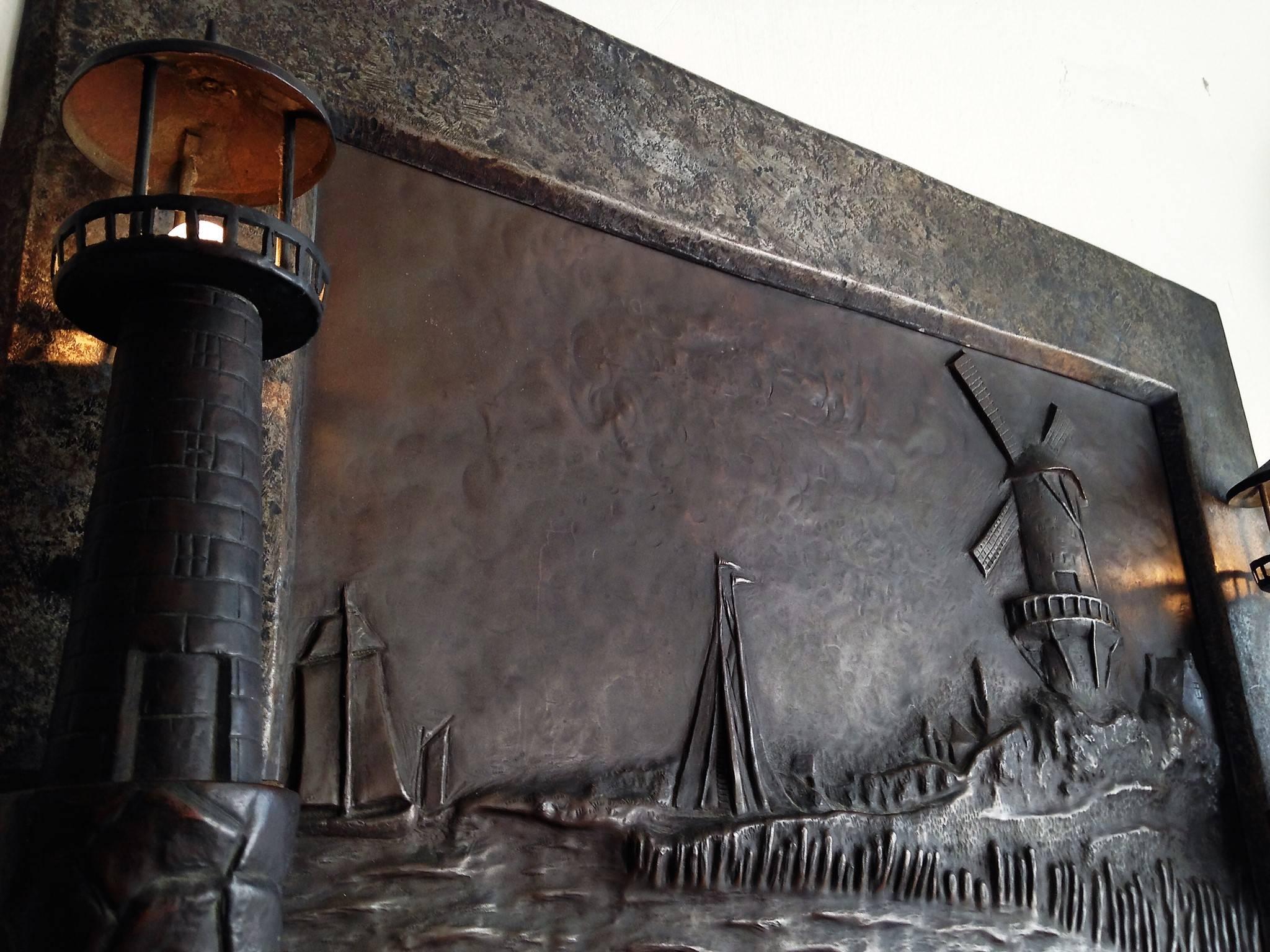 Bronze relief of ships on coastal shore with a windmill and two lighthouse lights. Masterfully done this is a very interesting illuminated wall plaque, with a switch on the lower right corner. In original antique condition. This is a mixed metal