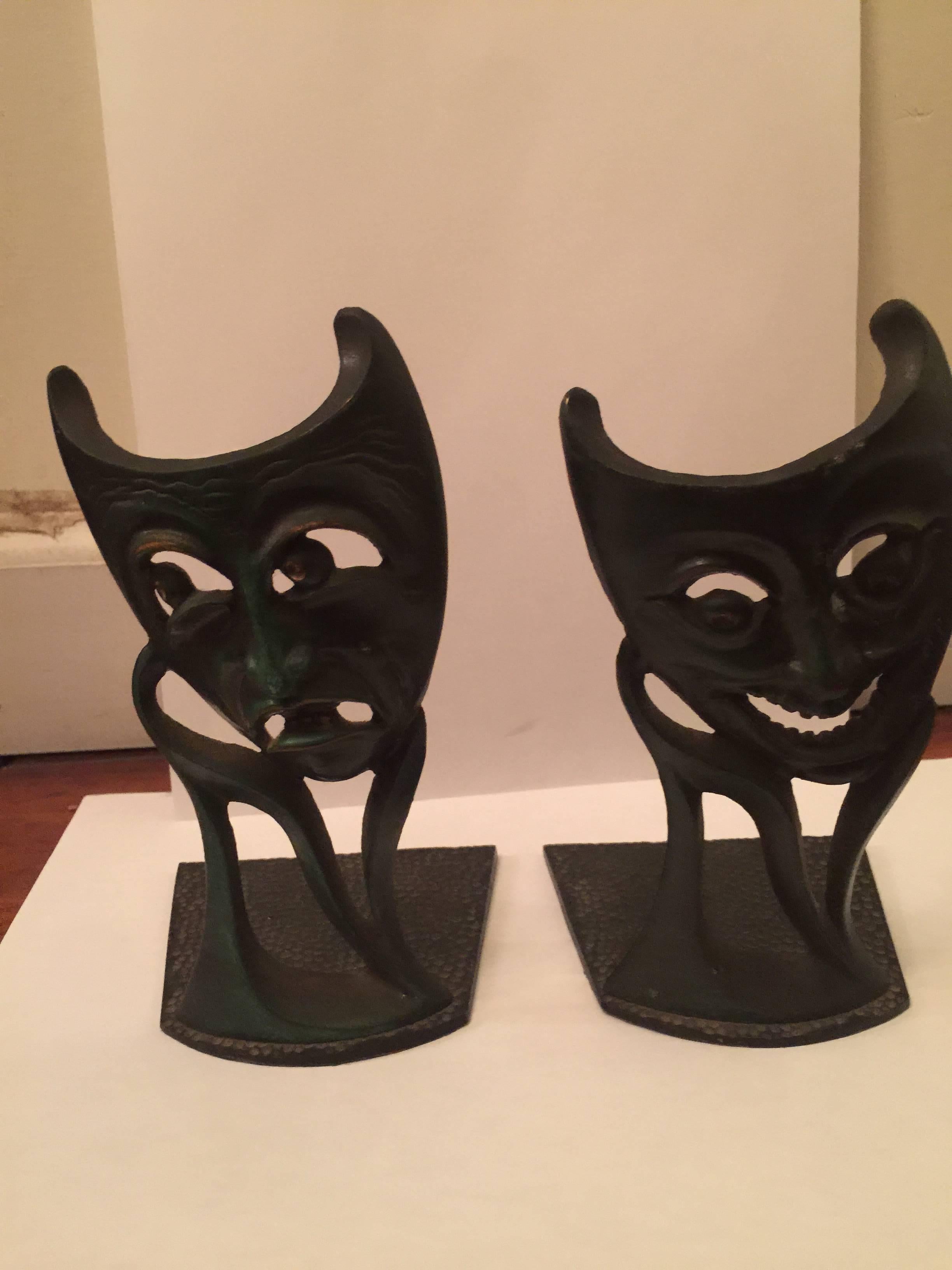 A terrific pair of Hollywood Regency style comedy and tragedy theatrical white metal bookends painted in green.
