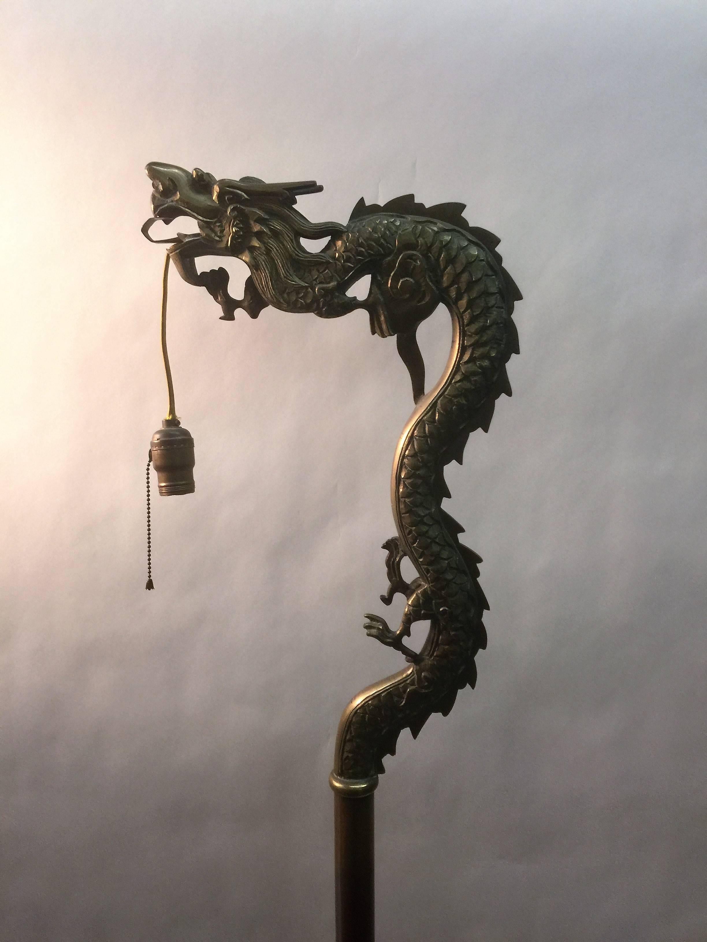 Nicely constructed cast and hand engraved brass dragon with tongue holding in the lamp fixture, made during the 1920s-1930s this is an interesting floor lamp with Foo dog face and foot feet. Would look cool in a interior with high end modern