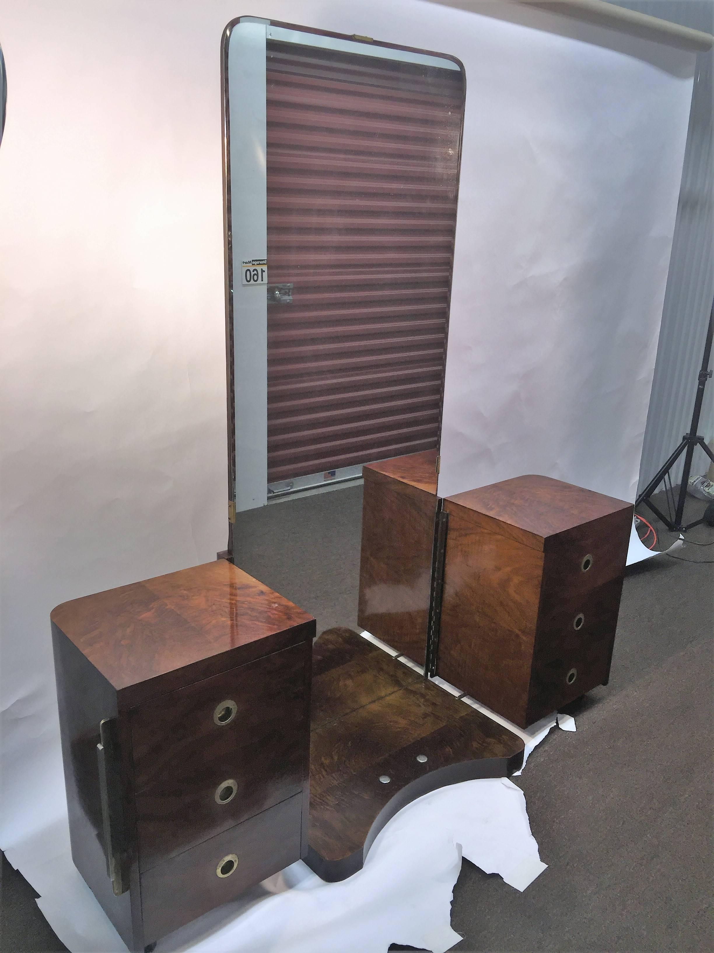 Deep burled wood Art Deco vanity with long center mirror. Cool design that opens to reveal six drawers of storage on caster wheels. Streamline nickel and brass skyscraper handles grace the chests. A really cool design in original untouched condition