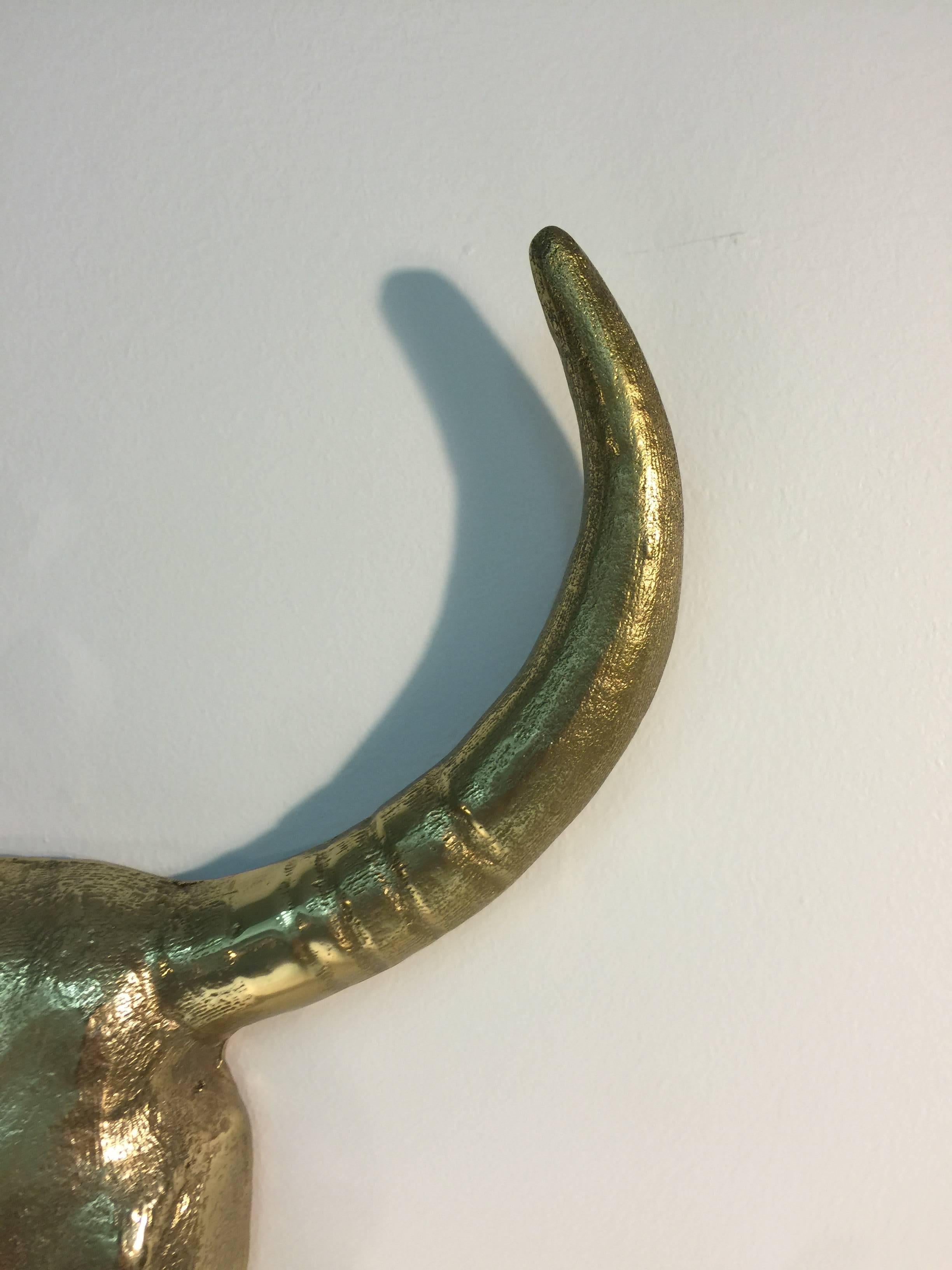 A pair of sculptural and substantial solid brass steer heads, circa 1970.