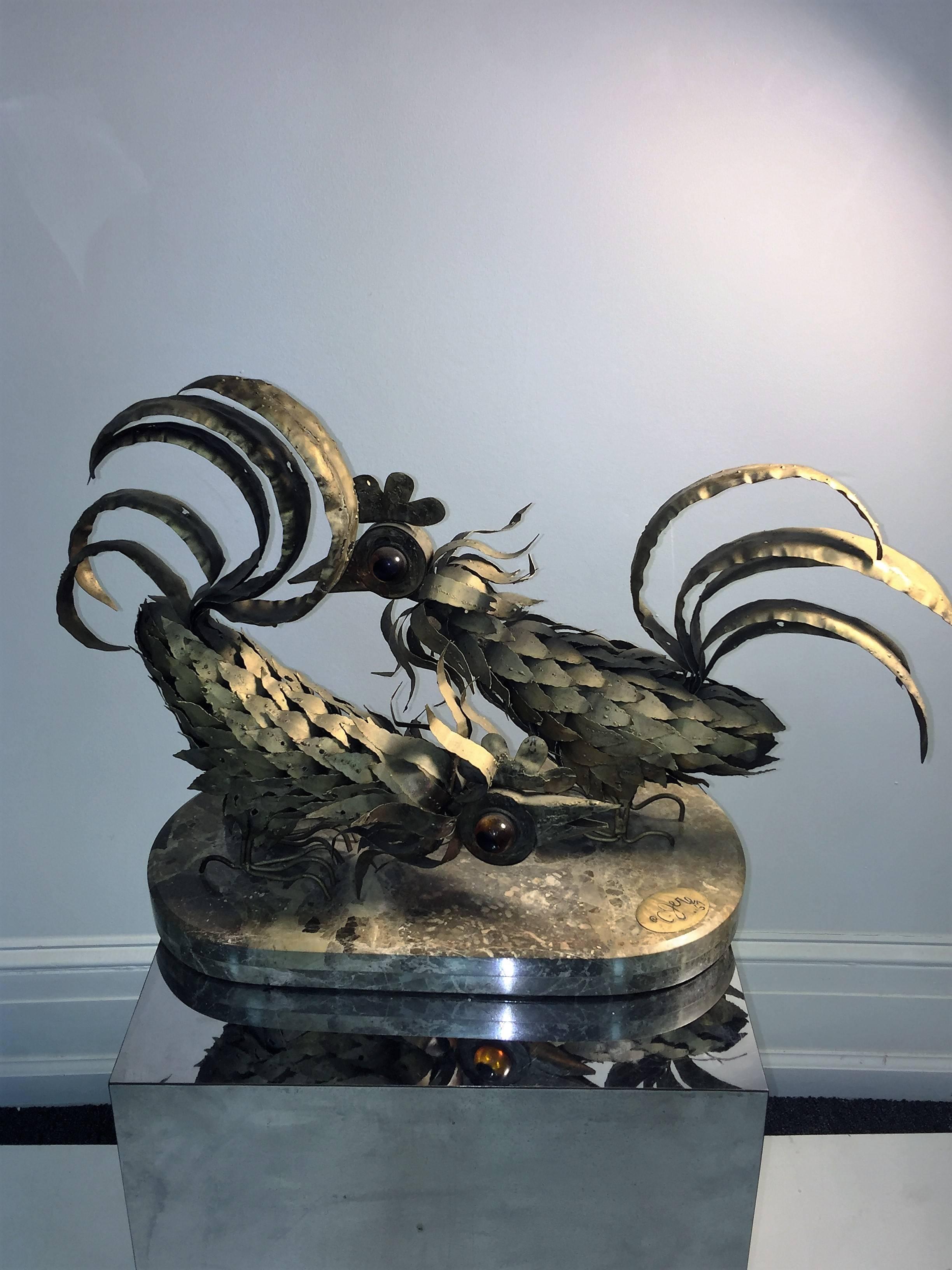Striking design Brutalist metal roosters with amber Lucite eyes sculpture on beautiful polished tan marble oblong base. Brass oval plaque signed c. Jere 67. Very substantial and well sculptured piece perfect for a high end modern interior on a
