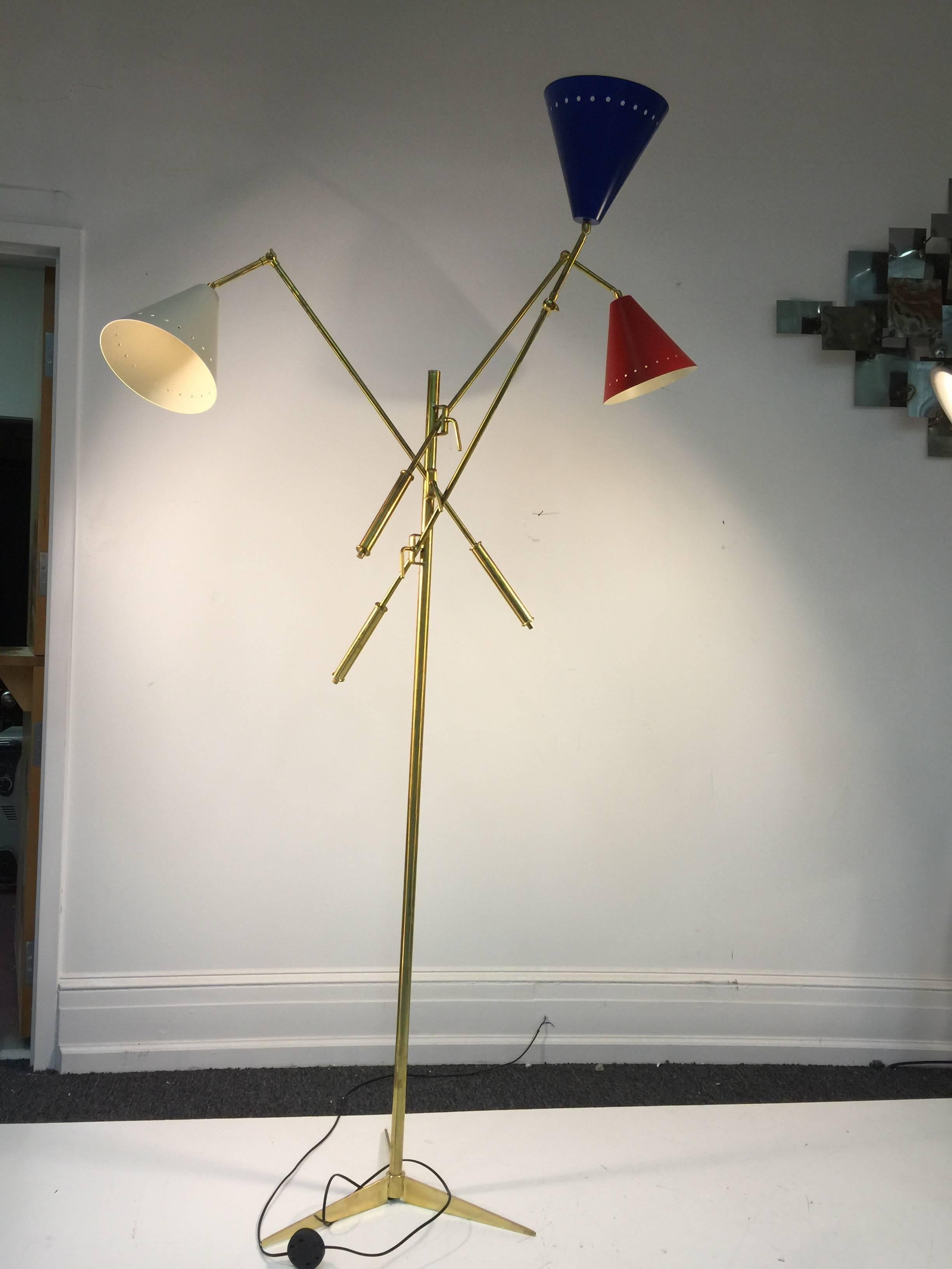 Terrific Triennale brass floor lamp on a tripod base with red, white, and blue shades designed after the Italian Lamp Master Arredoluce.
