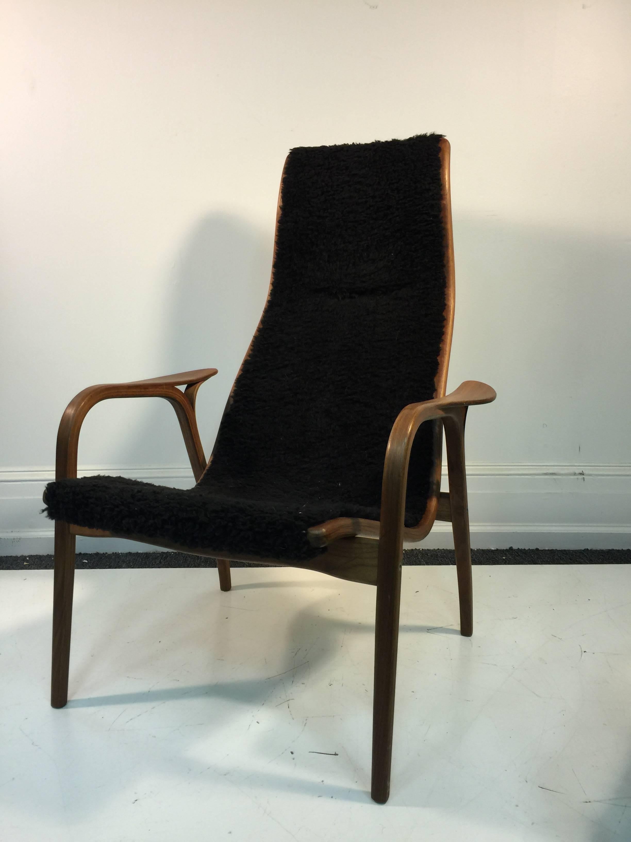 A Yngve Ekstrom Lamino high back lounge chair with matching ottoman made in Ystad, Sweden and upholstered in sheepskin, circa 1950.

Chair: 41 H x 30.5 D x 17.5 W x 16 S.
Ottoman: 19" H x 16" S x 18" D x 23.5" W.

 