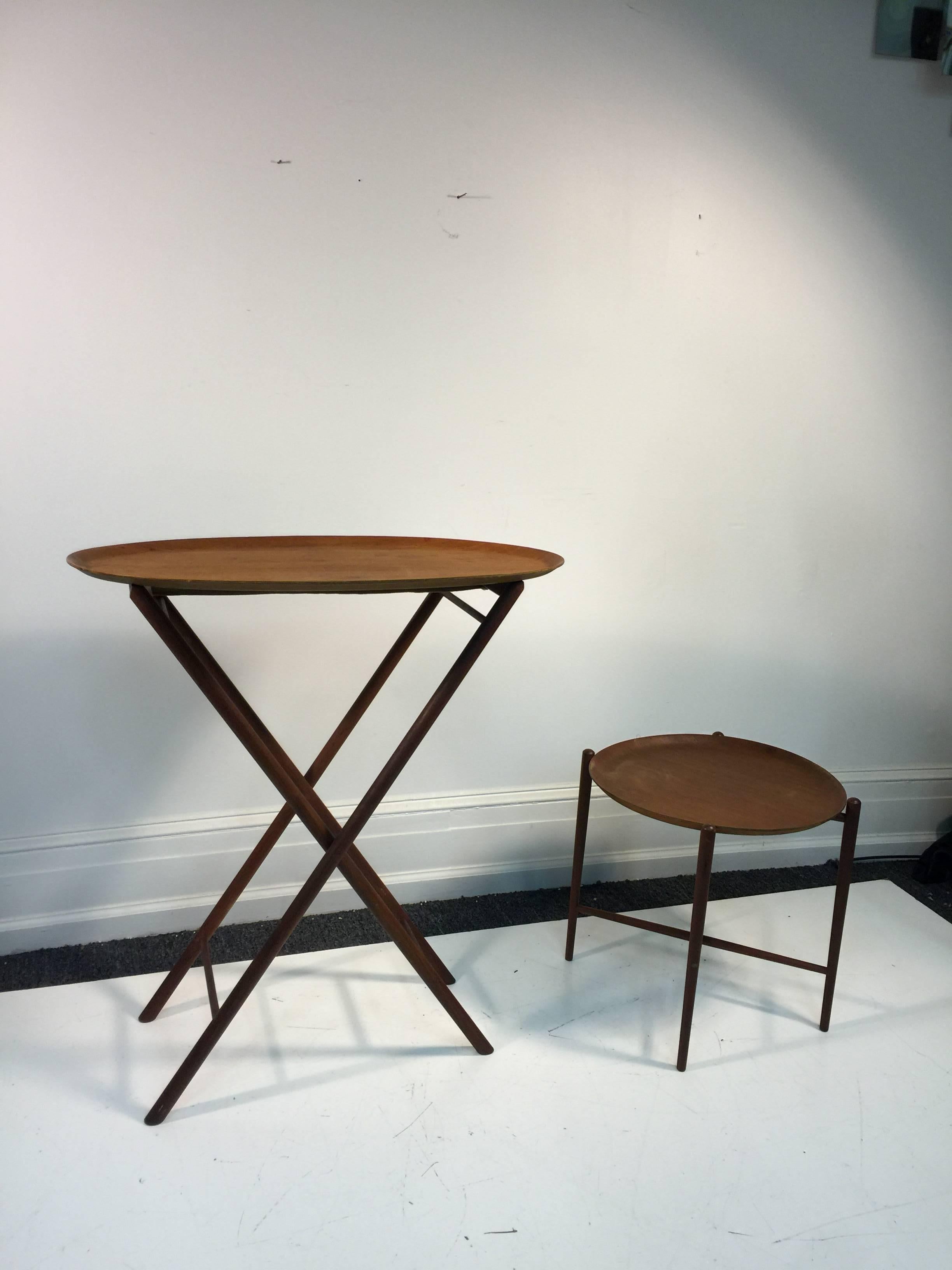 A terrific set of two 1970s Scandinavian Modern tray tables. The larger one has an oval top and is folding. The smaller one has a round top, X-base design, and tapered legs.
Measures:
Large: 33' W x 16