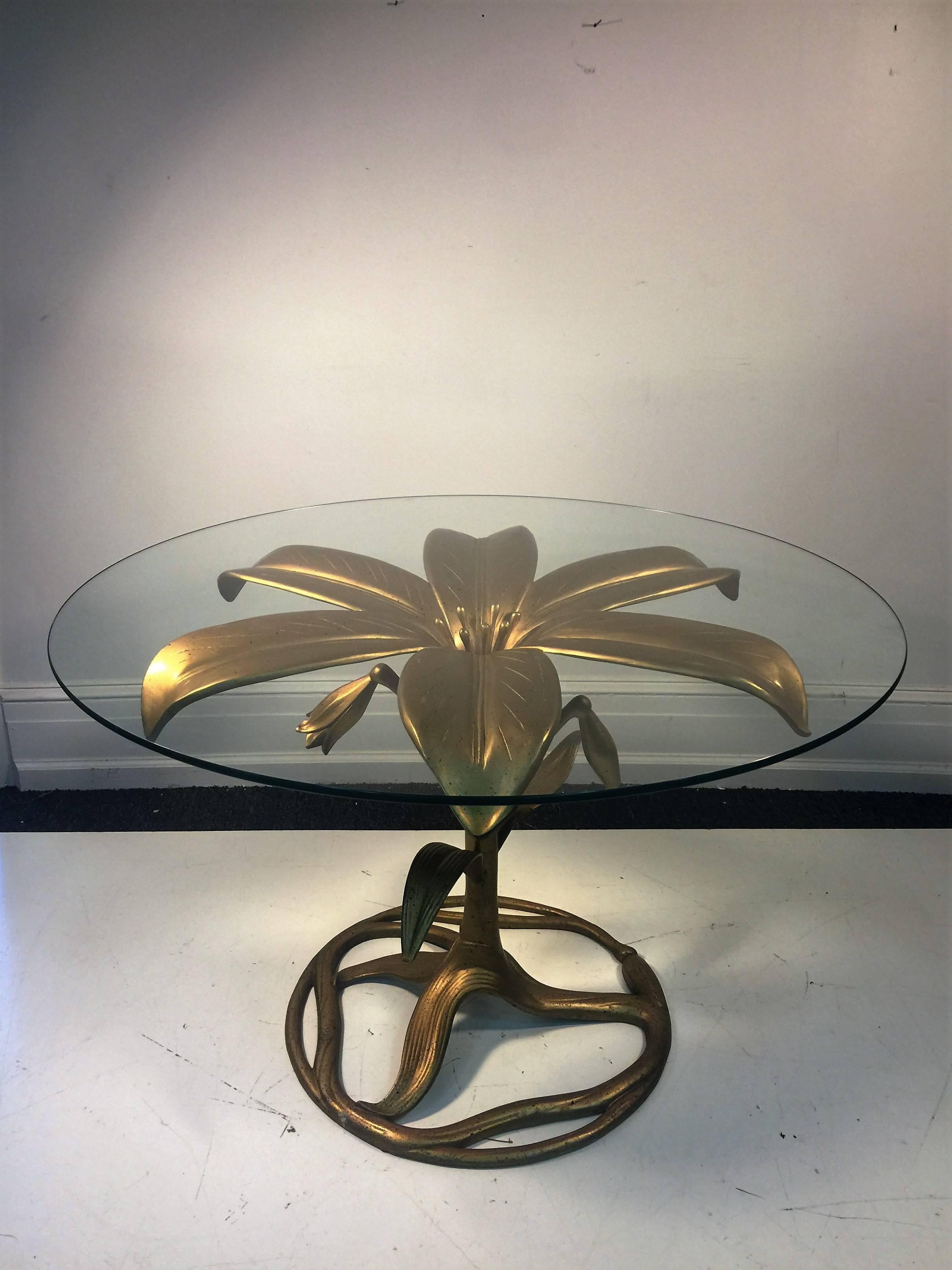 Perfect size Arthur Court dining table made of gilded cast aluminum in the form of a striking tiger lily with round glass top and four chairs with leopard upholstered chair seats with hanging black tassel and rope. High end decorative dining suite