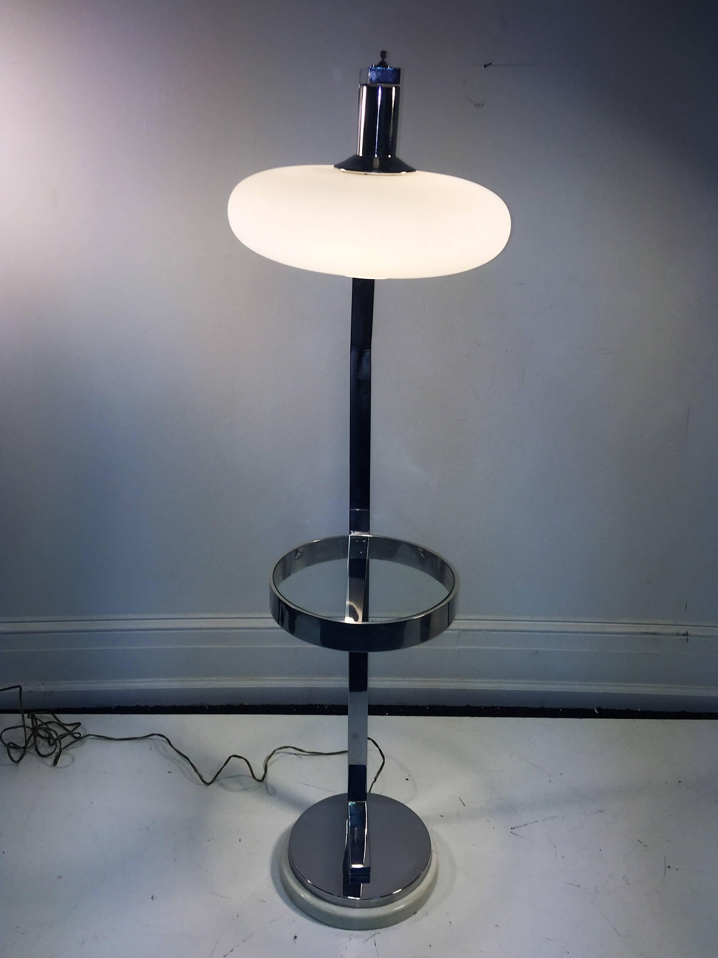 Striking design Italian floor lamp with white frosted glass shade and circular glass table attached to the center of the lamp. Heavy and substantial chromed bronze frame mounted on Carrera marble base. Great as a reading lamp next to your Modern