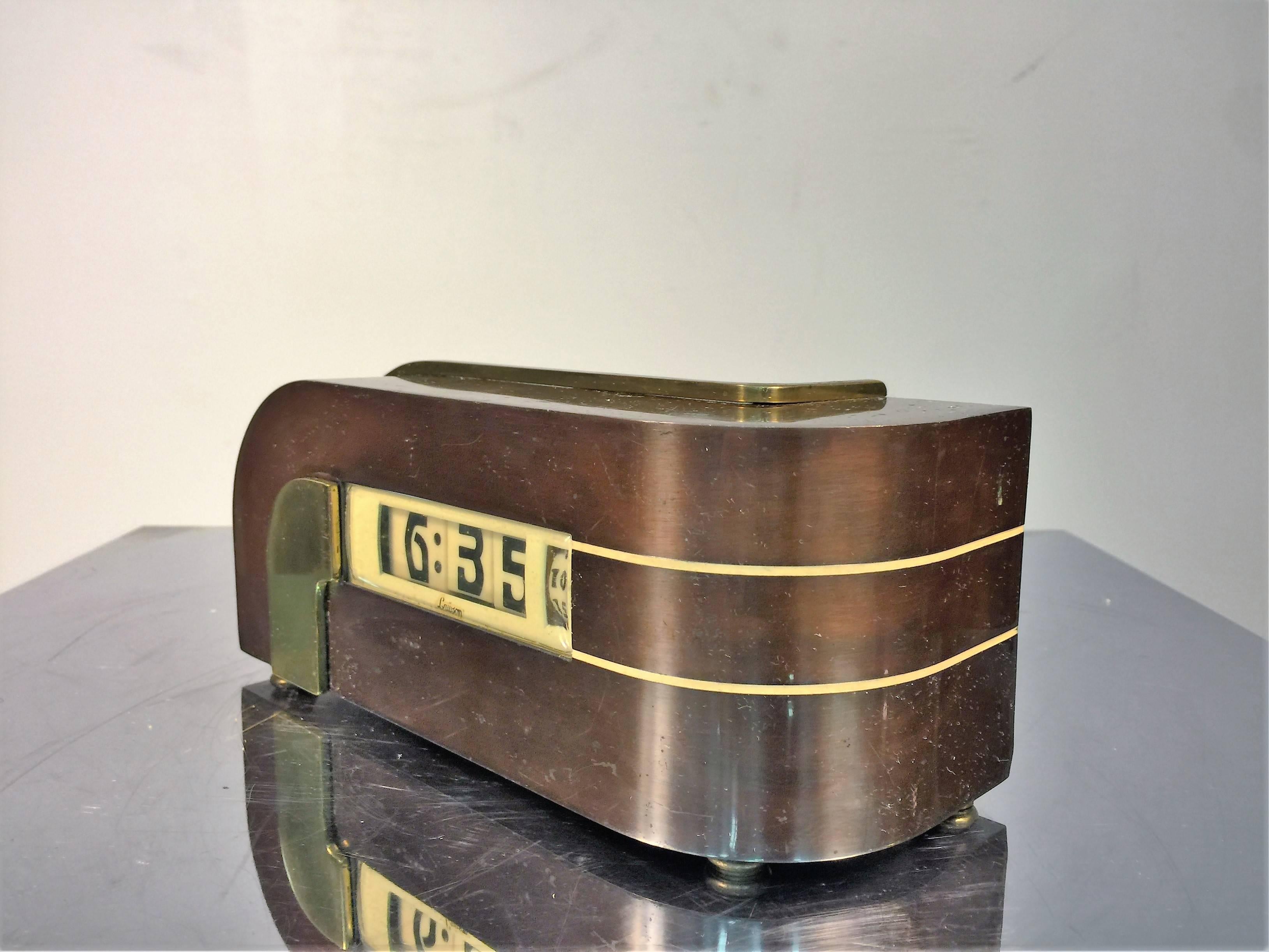 Great design burnished bronze and brass with ivory enameled trim fantastic Machine Age design electric clock designed in the 1930s. Great Art Deco stylized numbers in a digital form with the seconds wheel. Made by Lawson this clock runs beautifully