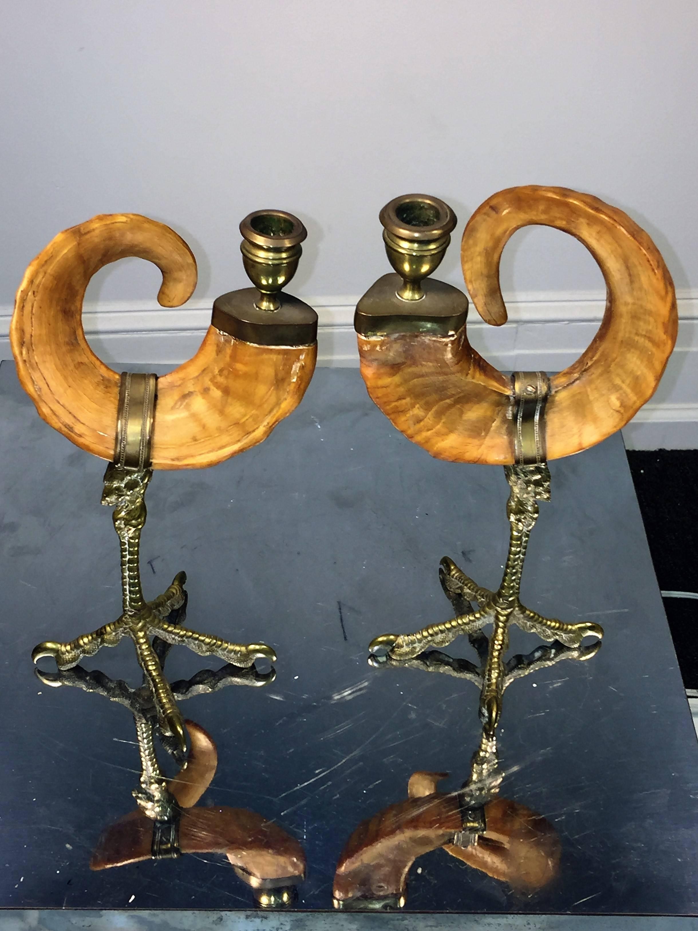 Interesting pair of brass and ram horn candlesticks formed to mimic a pair of fancy cockerels with the tail being the curved ram horn. These would look great on a fancy coffee table or console and would be nice for a candle lit dining table. The