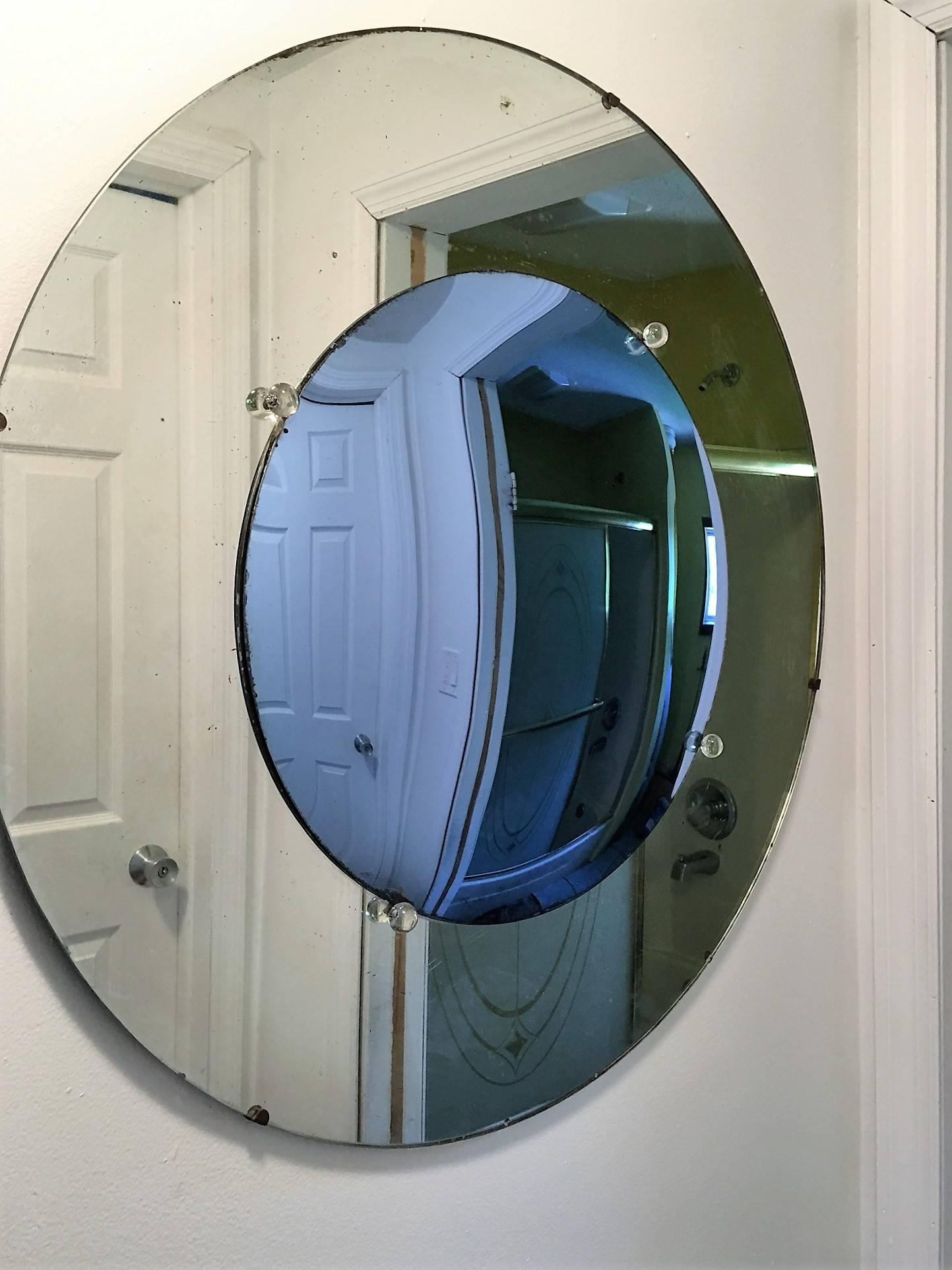 Great convex form Art Deco mirror in the hues of cobalt blue and clear. The blue center is framed by four decorative glass balls, a period of Streamline design, 1930s. Mirror looking futuristic yet past. Mounted on wood, all original and sturdy,
