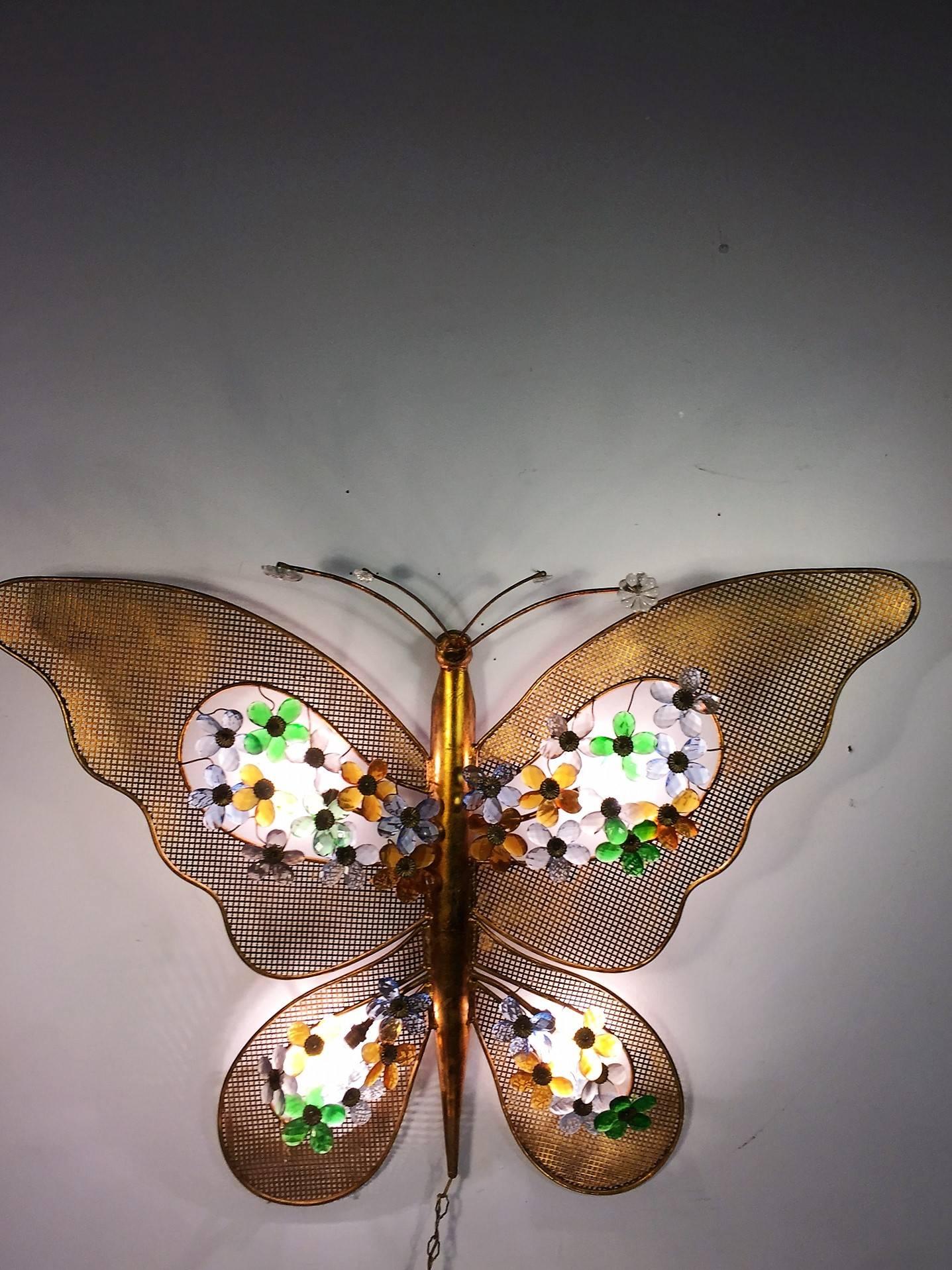 Amazing gilded Italian butterfly with the wings encrusted with colorful crystal flowers above the light sockets. Designed of gilded decorative metal the antennae have colorful crystal flowers and clear crystal accents. Designed with recessed eyes