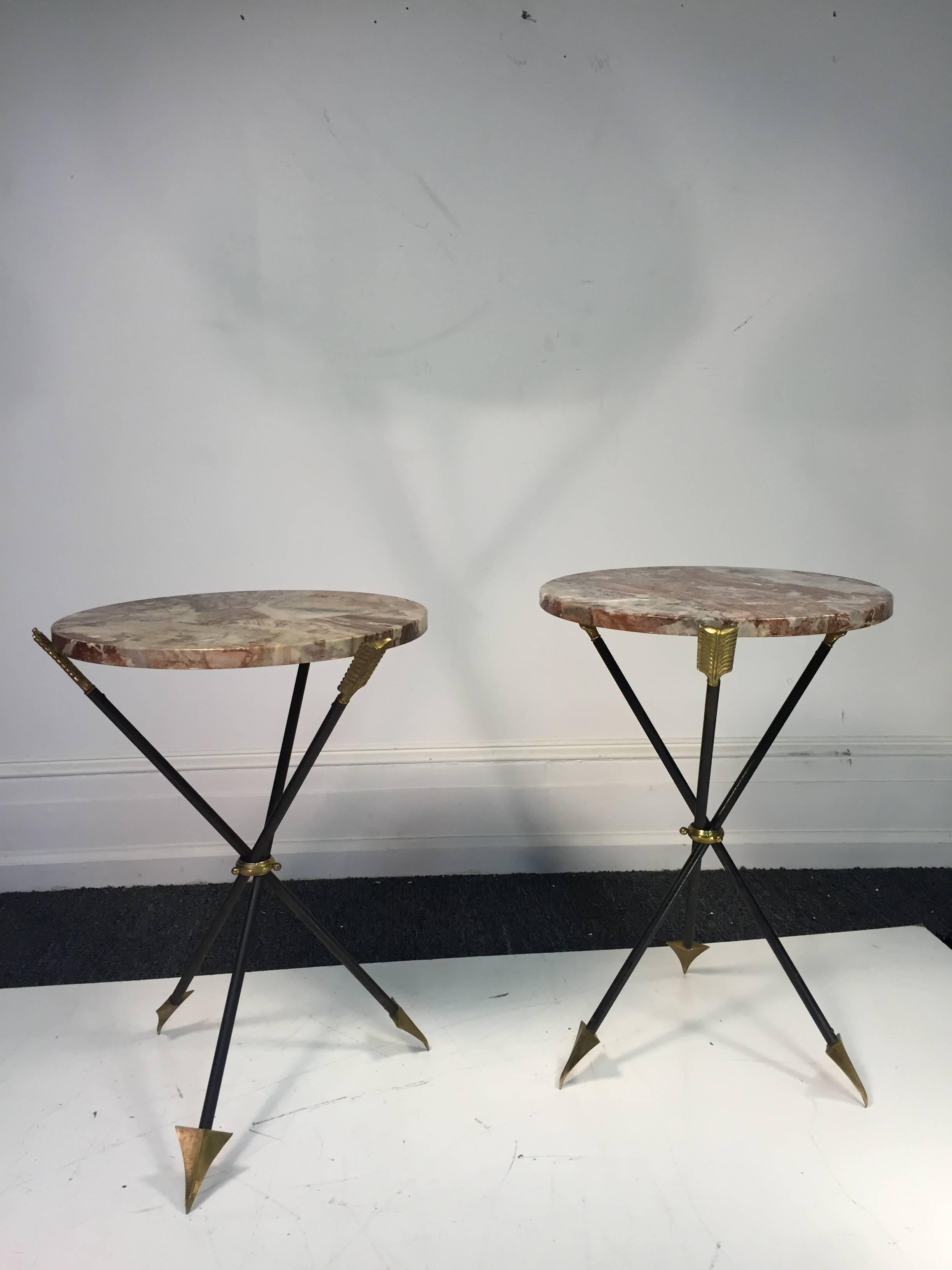 An exceptional pair of French brass and iron arrow side or end tables with marble tops attributed to Maison Jansen, circa 1950.