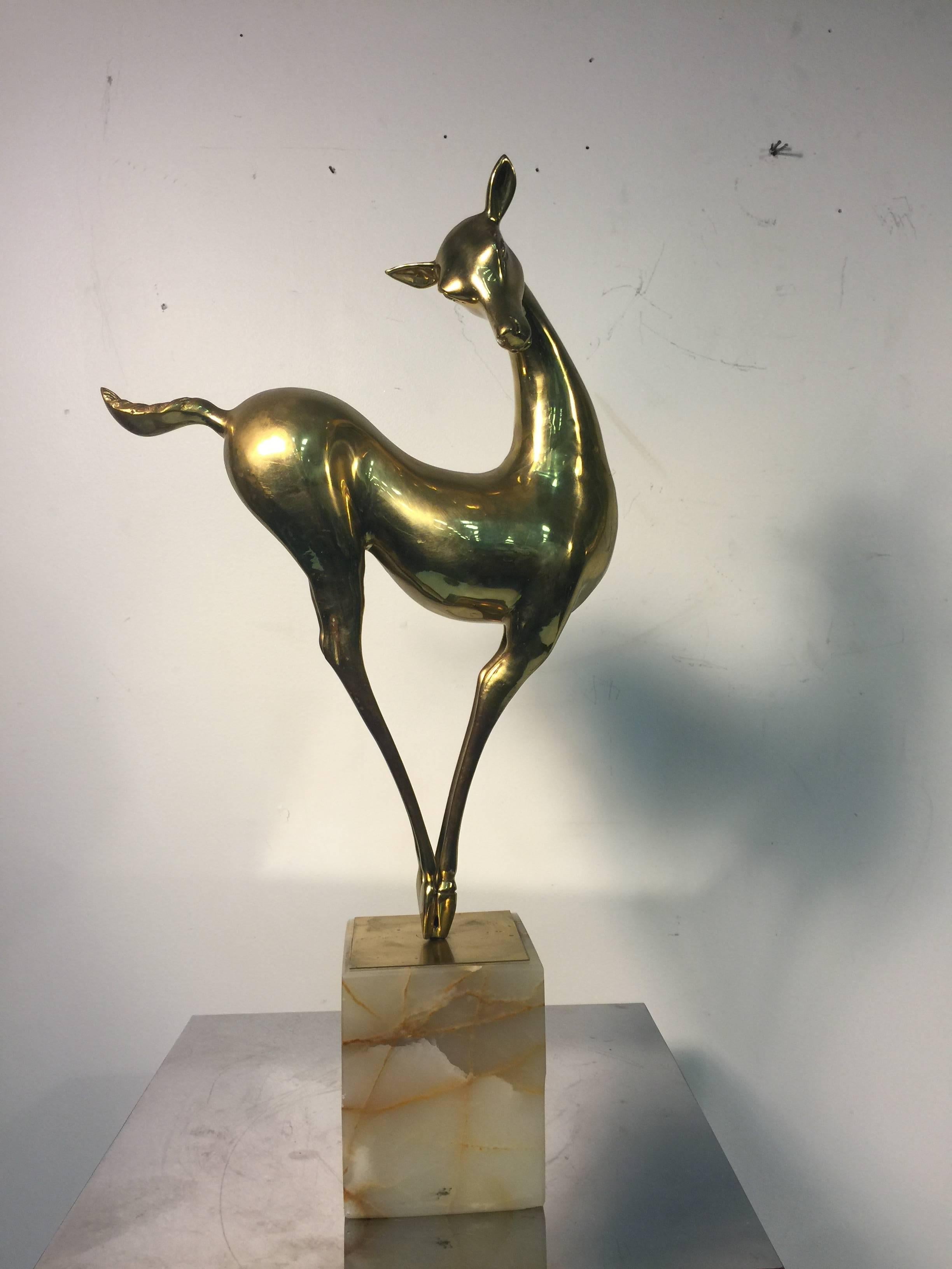 An elegant and rare brass Curtis Jere deer sculpture on an onyx base, signed C. Jere, and dated 1986.