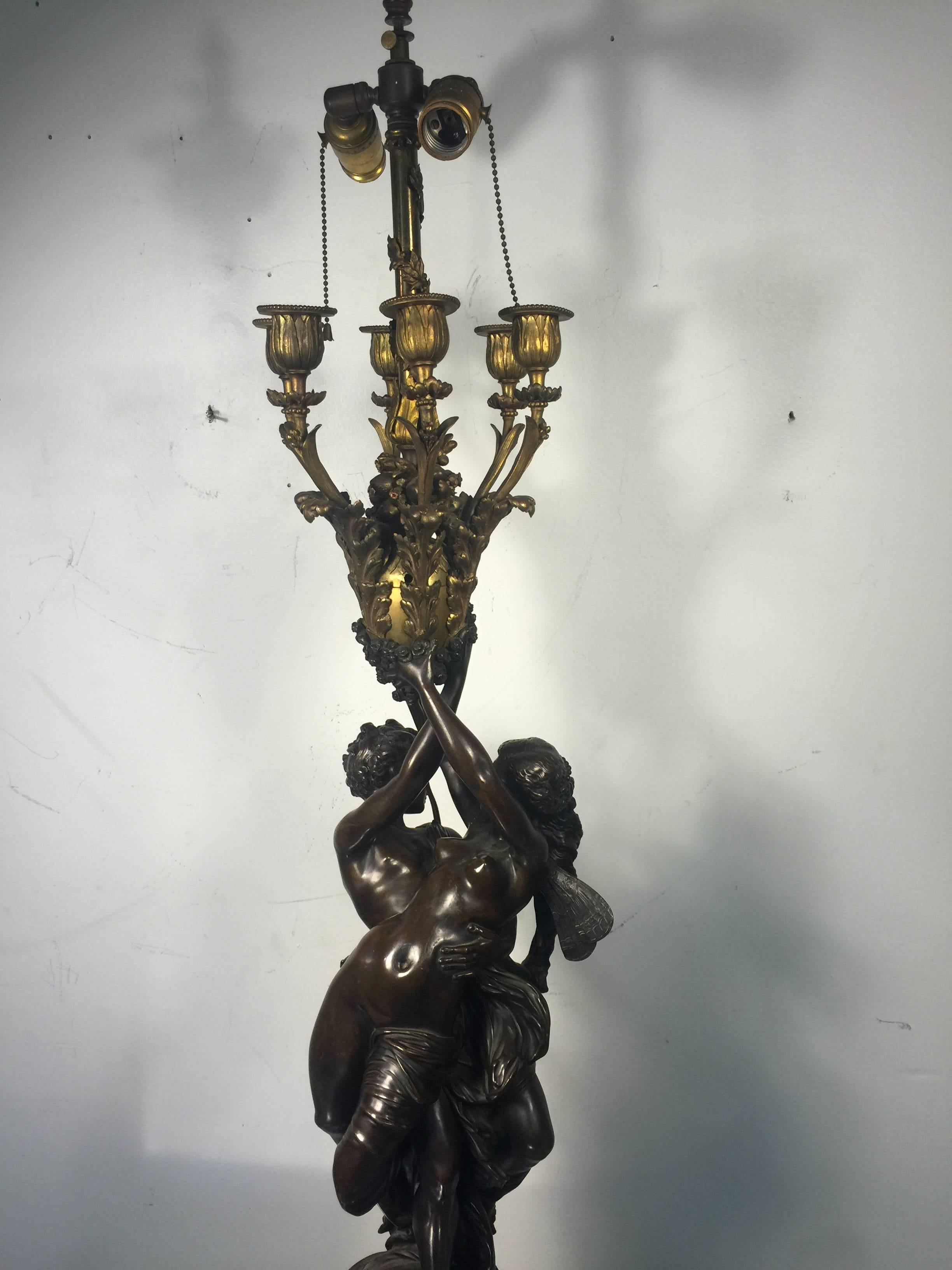 A monumental pair of 19th century, French, doré bronze Louis XV style figural six-light candelabra table lamps with exceptional detail. Good condition with age appropriate wear.
