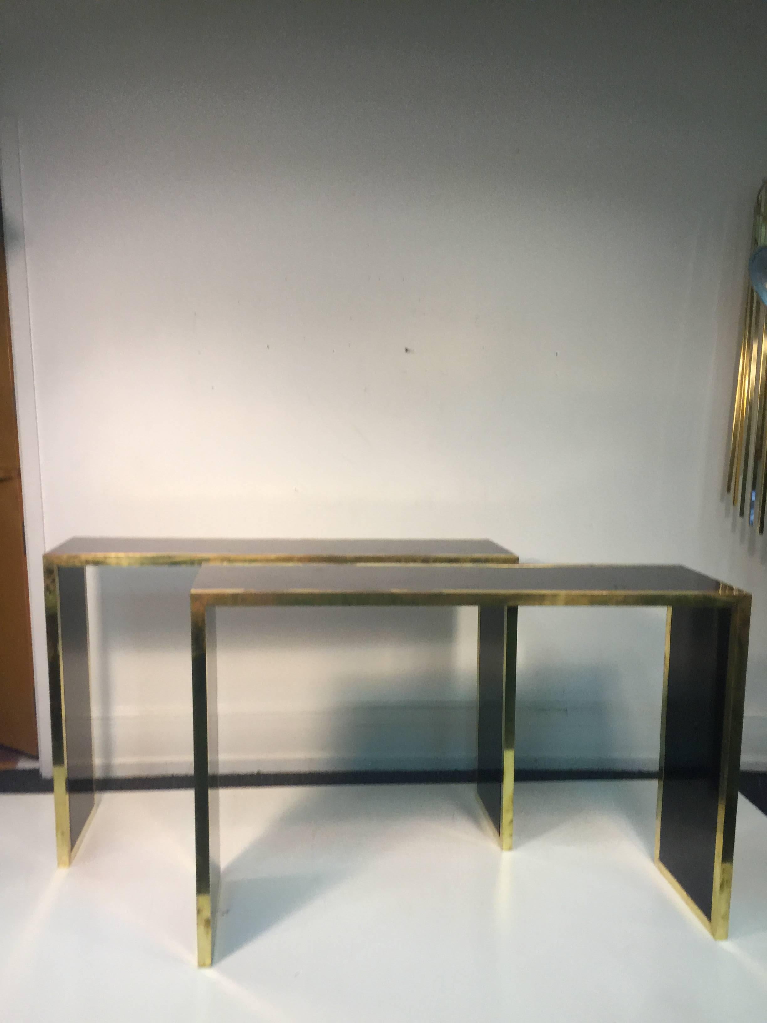 An elegant pair of Alain Delon style black lacquer and brass French console tables, circa 1970. Good condition with age appropriate wear.