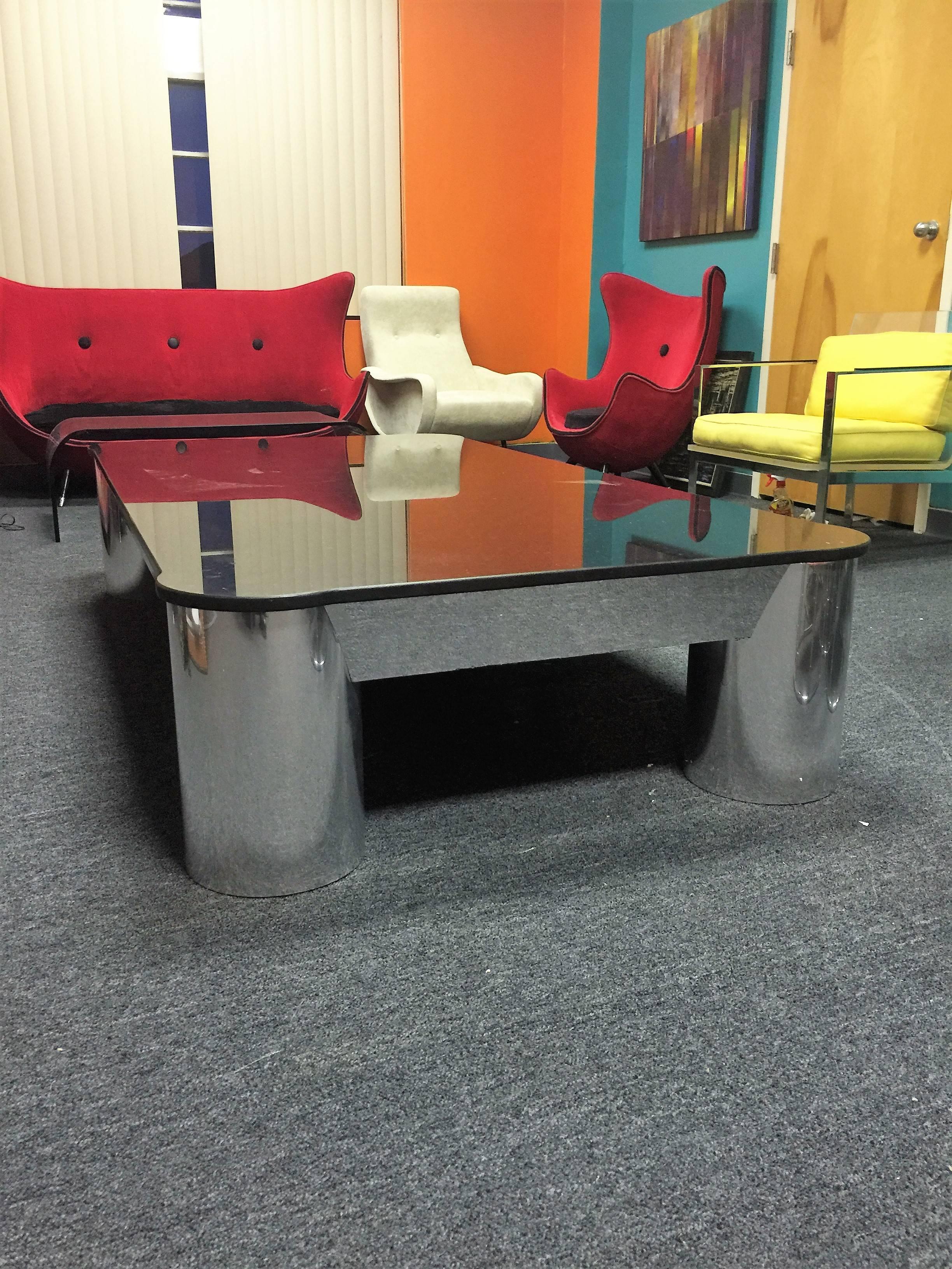 Amazing heavy polished black granite topped modernistic design coffee table formed with chromed metal steel over a solid wood form base with four cylinder form legs. An extraordinary mammoth custom coffee table that is solid and striking. The