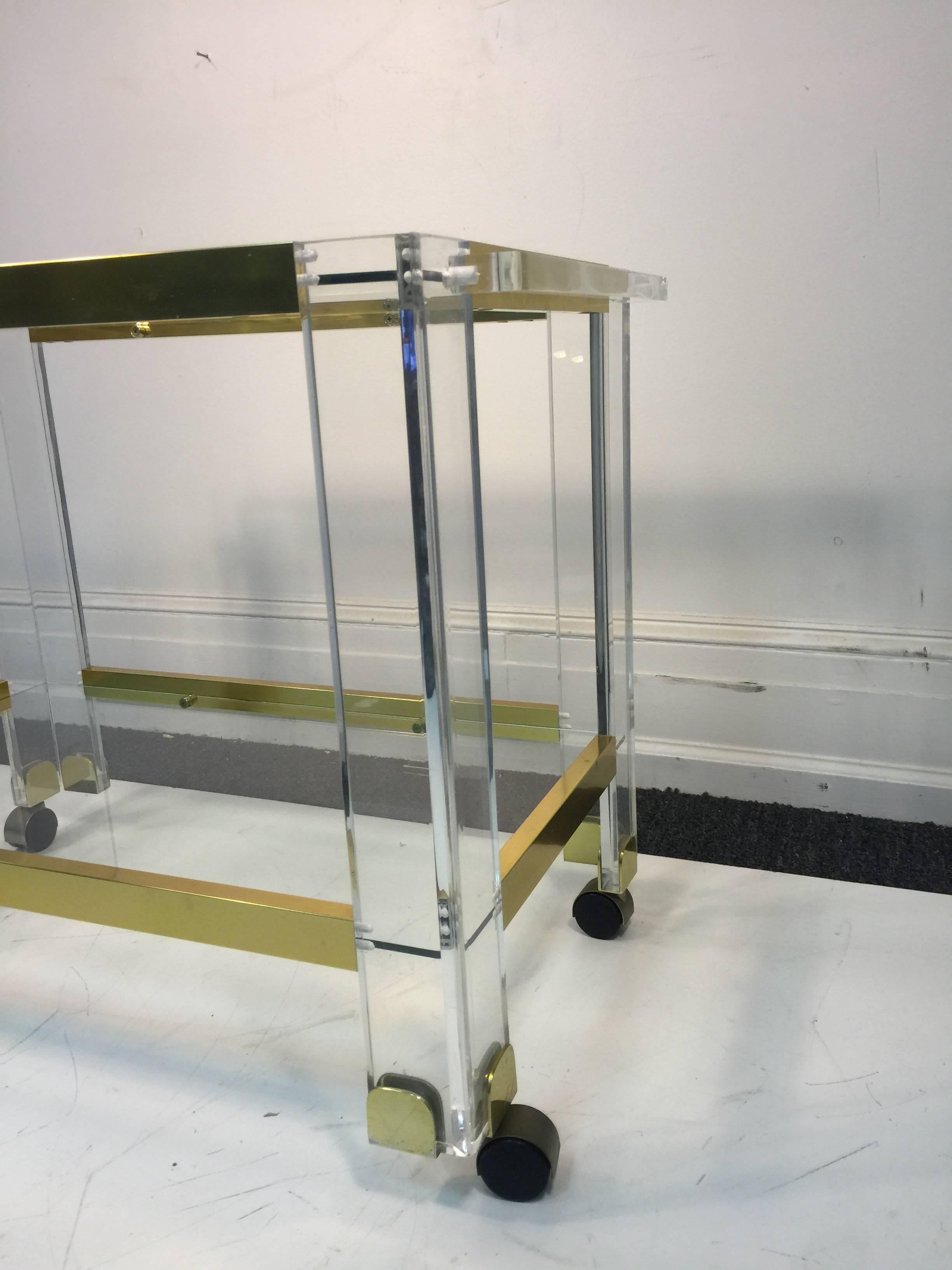A stunning brass and Lucite two-tier bar cart by Charles Hollis Jones, circa 1970. Good condition with age appropriate wear.
