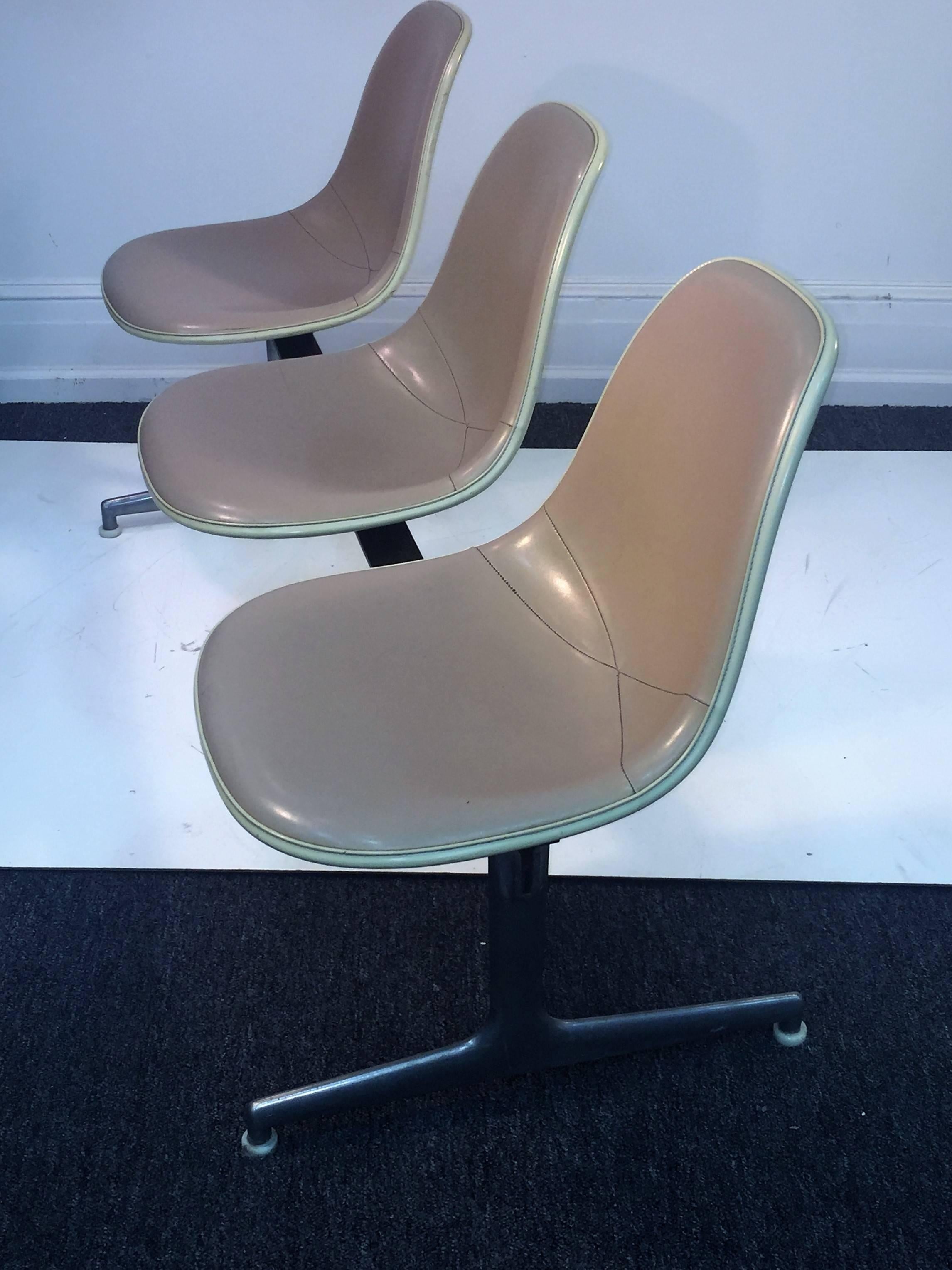 Wonderful tan stitched leather and cream fiberglass bucket design seat triple lounge. A great modernist aluminum base with the fixed seating upon a blackened iron bar. Would be an excellent choice in a modernist living room.