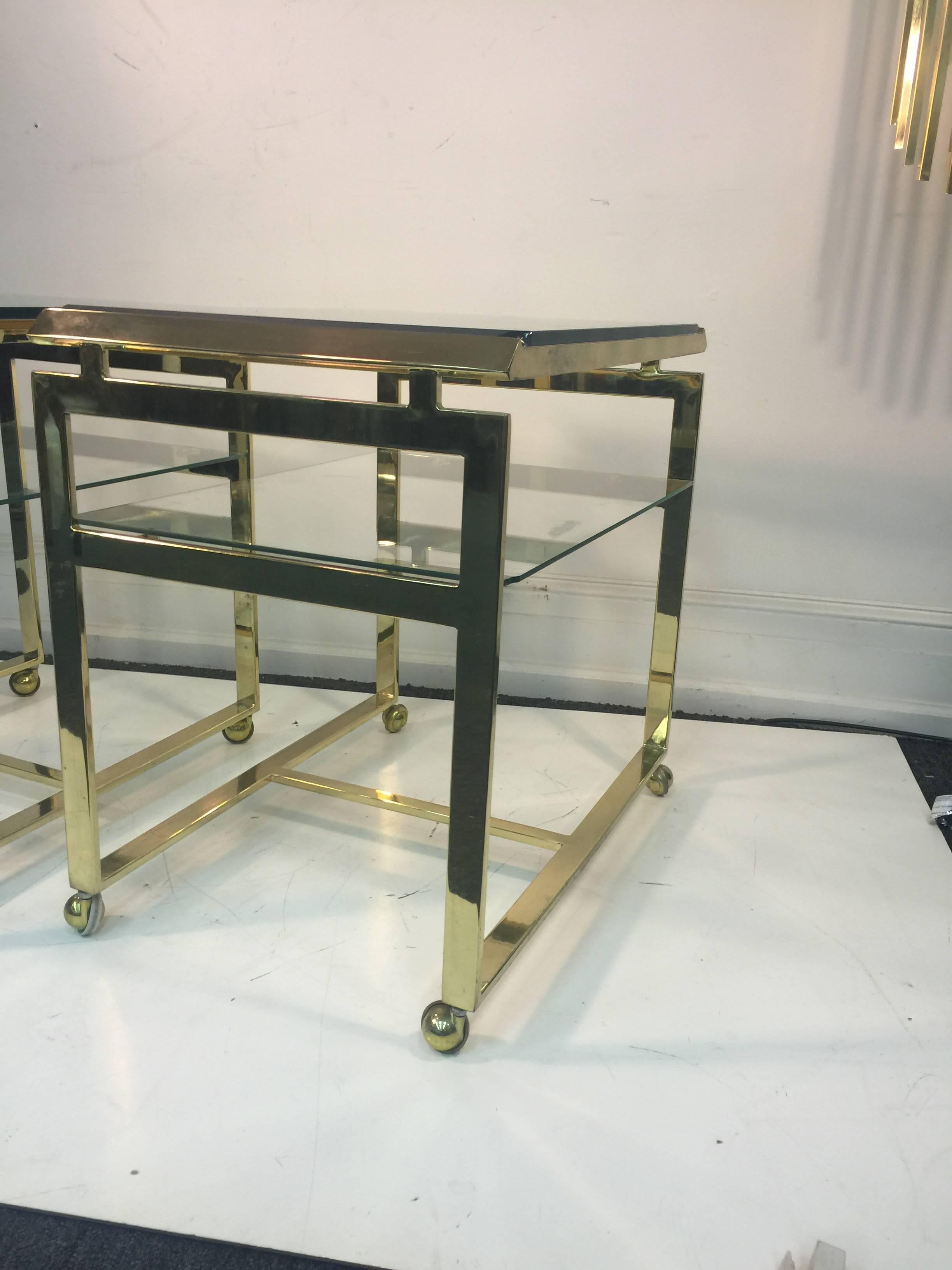 A striking pair of brass and glass flat bar tea or serving carts by Milo Baughman, circa 1970. Good vintage condition with age appropriate wear.
 