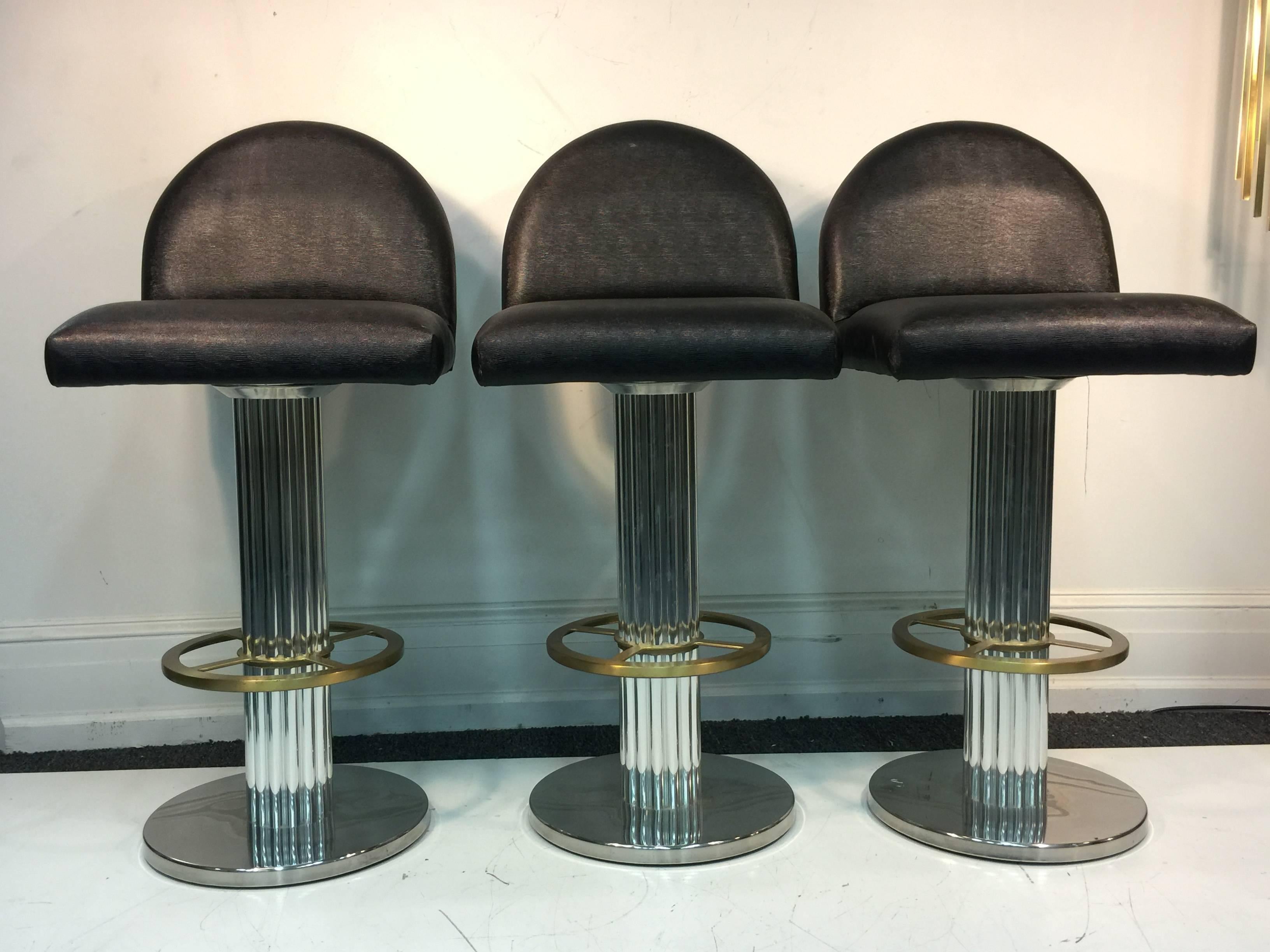 A fabulous set of three chrome and brass bar stools with rich faux lizard upholstery. Original label underneath. Manufactured in 1995.