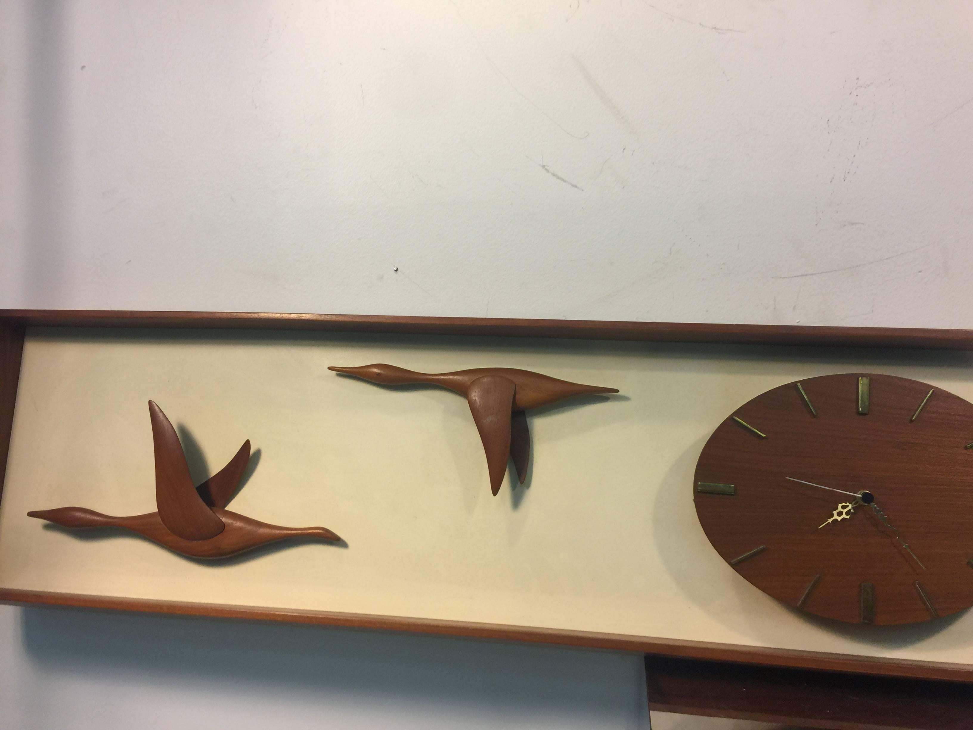 A fantastic Mid-Century Modern hand-sculpted teak wall clock with geese in flight, circa 1960.