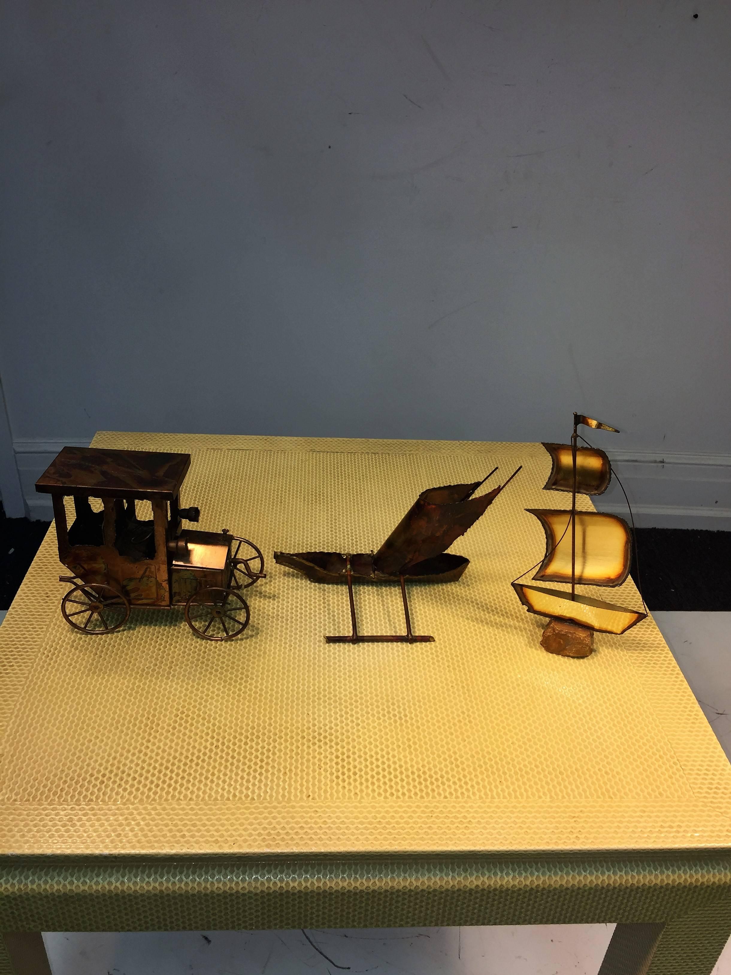 Trio of brutalist mixed metal sculptures with original tag, cool musical model “T” ford, catamaran boat and galleon with flag on onyx base.
Model “T” ford is a music box and the cars crank start is the winder and the cars hood moves up and down