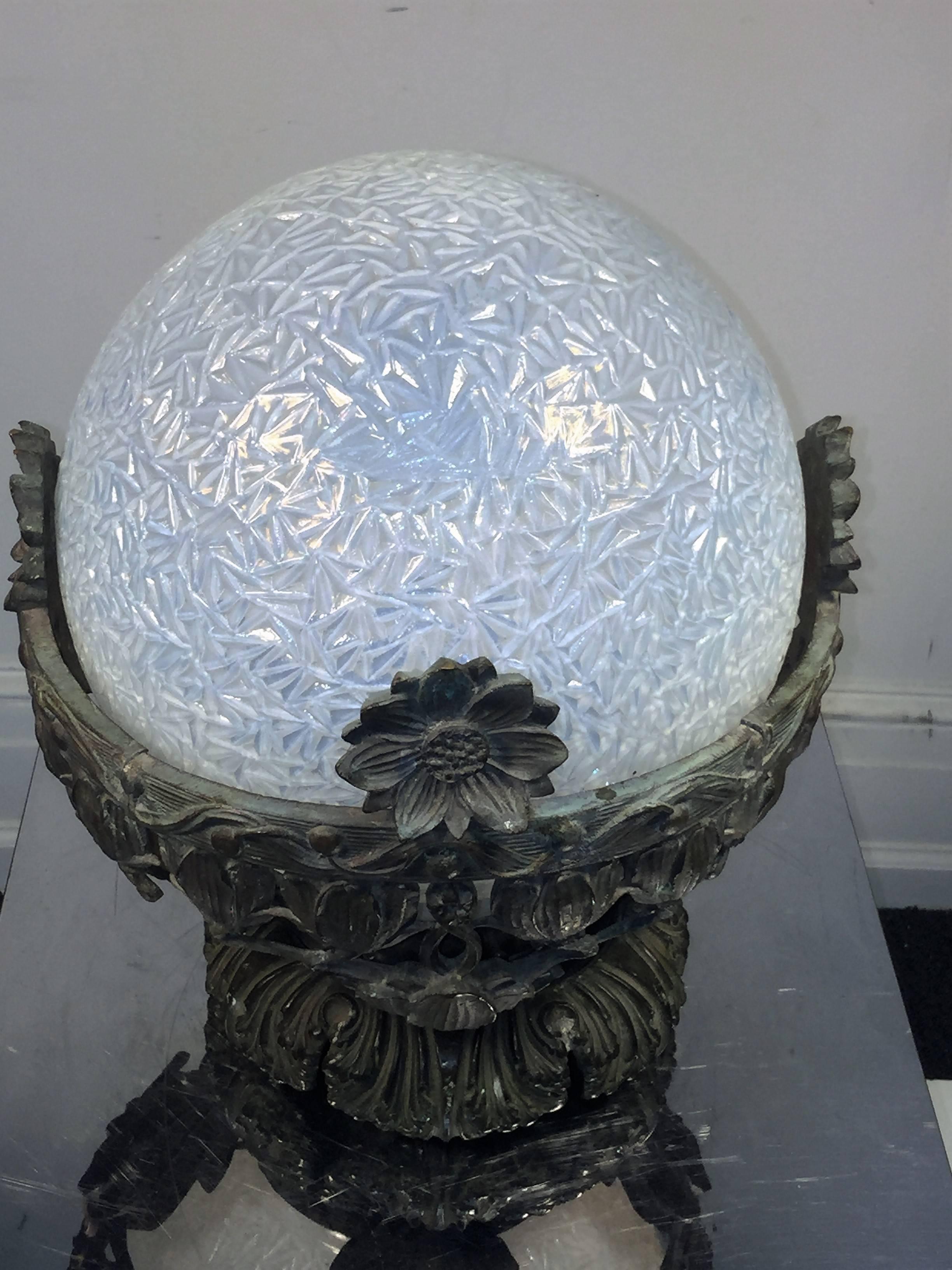 Substantial cast bronze with various flowers and designs. Ice design opalescent pale blue glass sphere is the globe. This is not fitted with a light fixture and needs some adjustment to be hung on the ceiling, but can be done easily enough. Designed